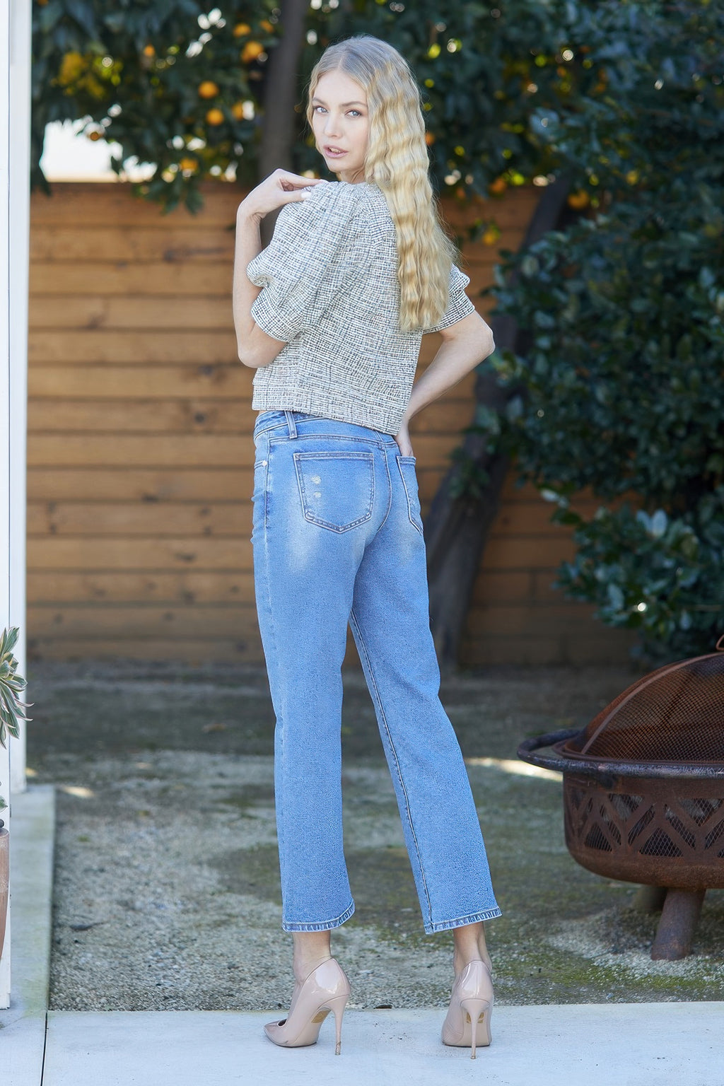 Back view of light blue mid-rise crop slim bootcut jeans with bootcut leg shape