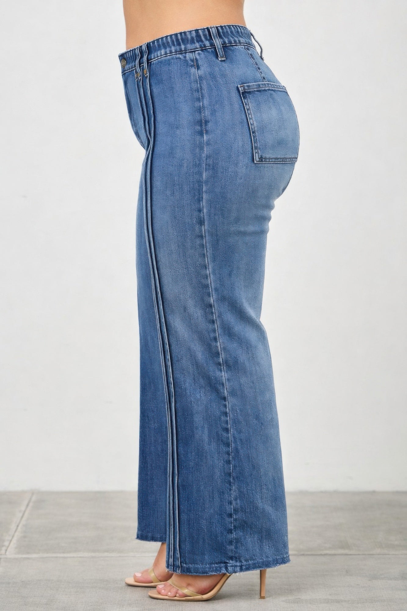 High-rise straight jeans, side view: dark blue denim with vertical seam detail