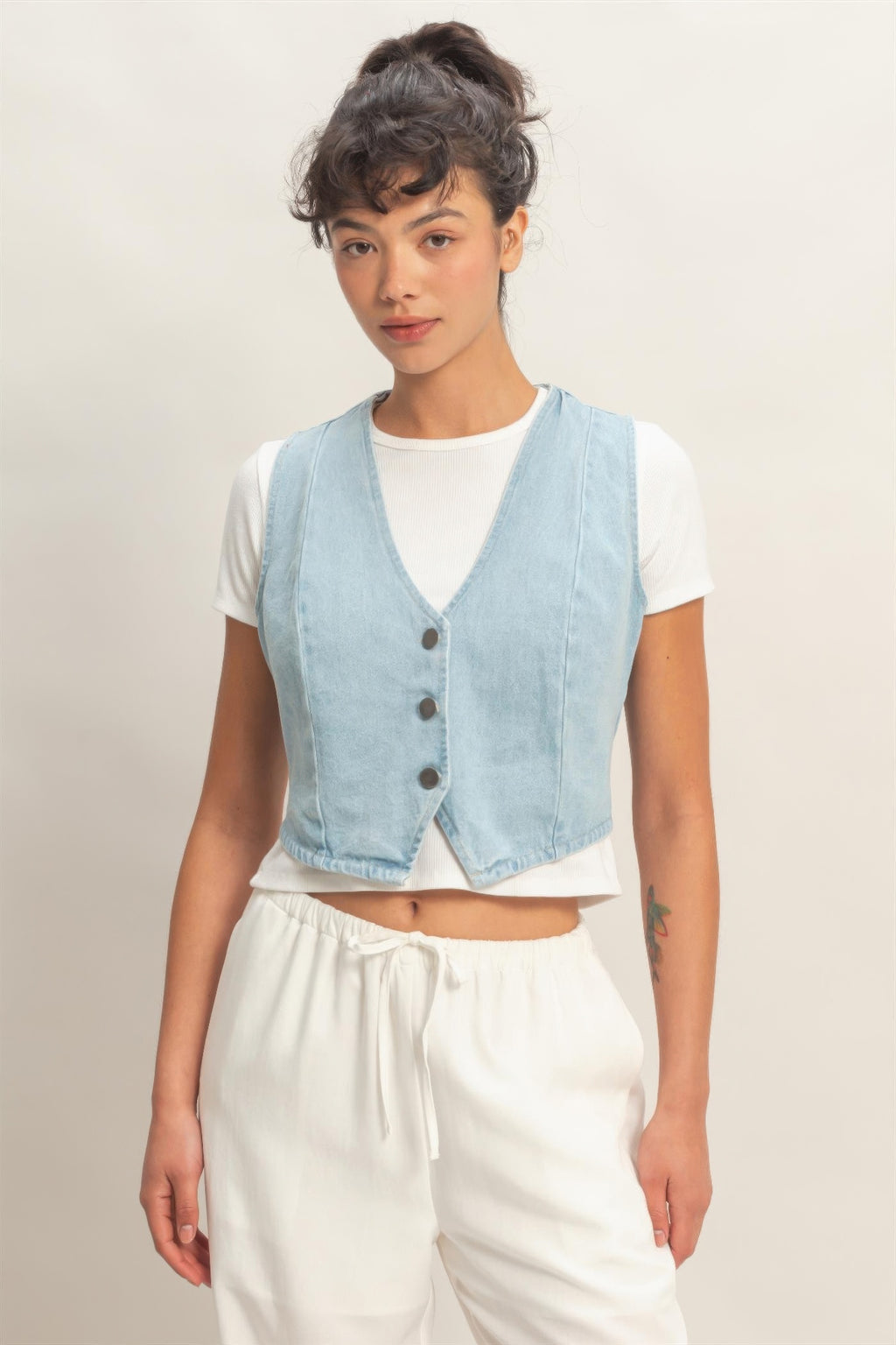 Light blue V-neck sleeveless denim vest with button front and patch pockets