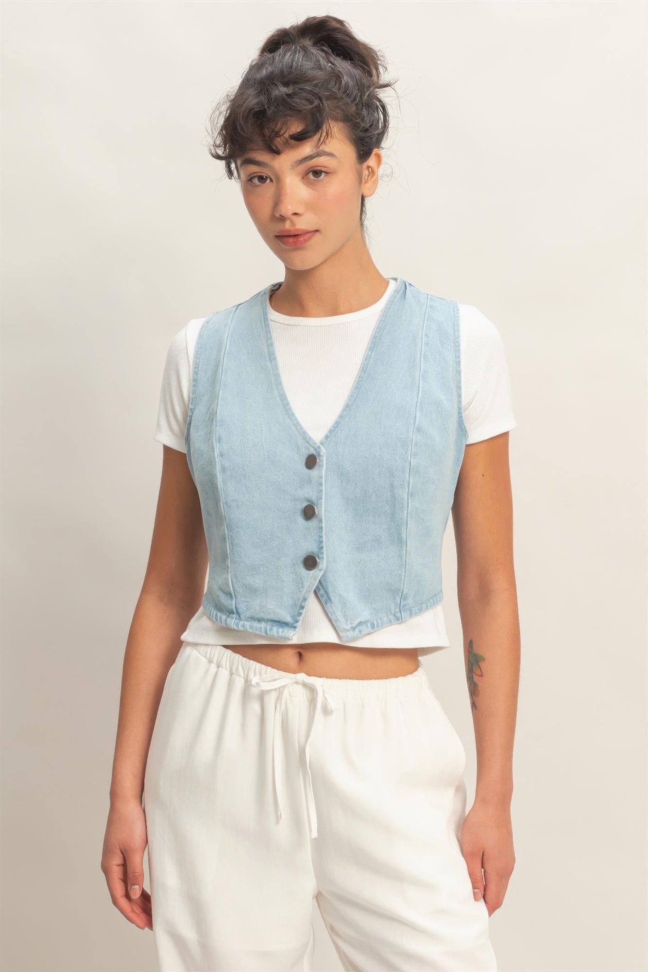 Light blue V-neck sleeveless denim vest with button front and patch pockets