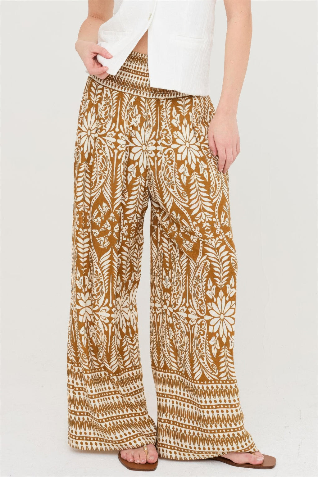 Smocked waist floral pants in brown with wide-leg fit and allover botanical print