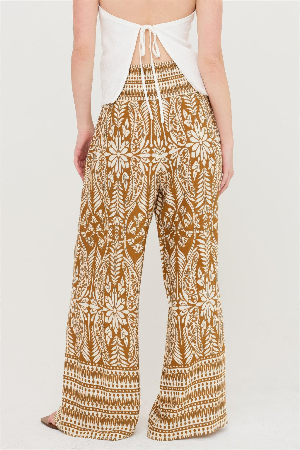 Brown floral smocked waist wide-leg pants with white border stripes and allover motif
