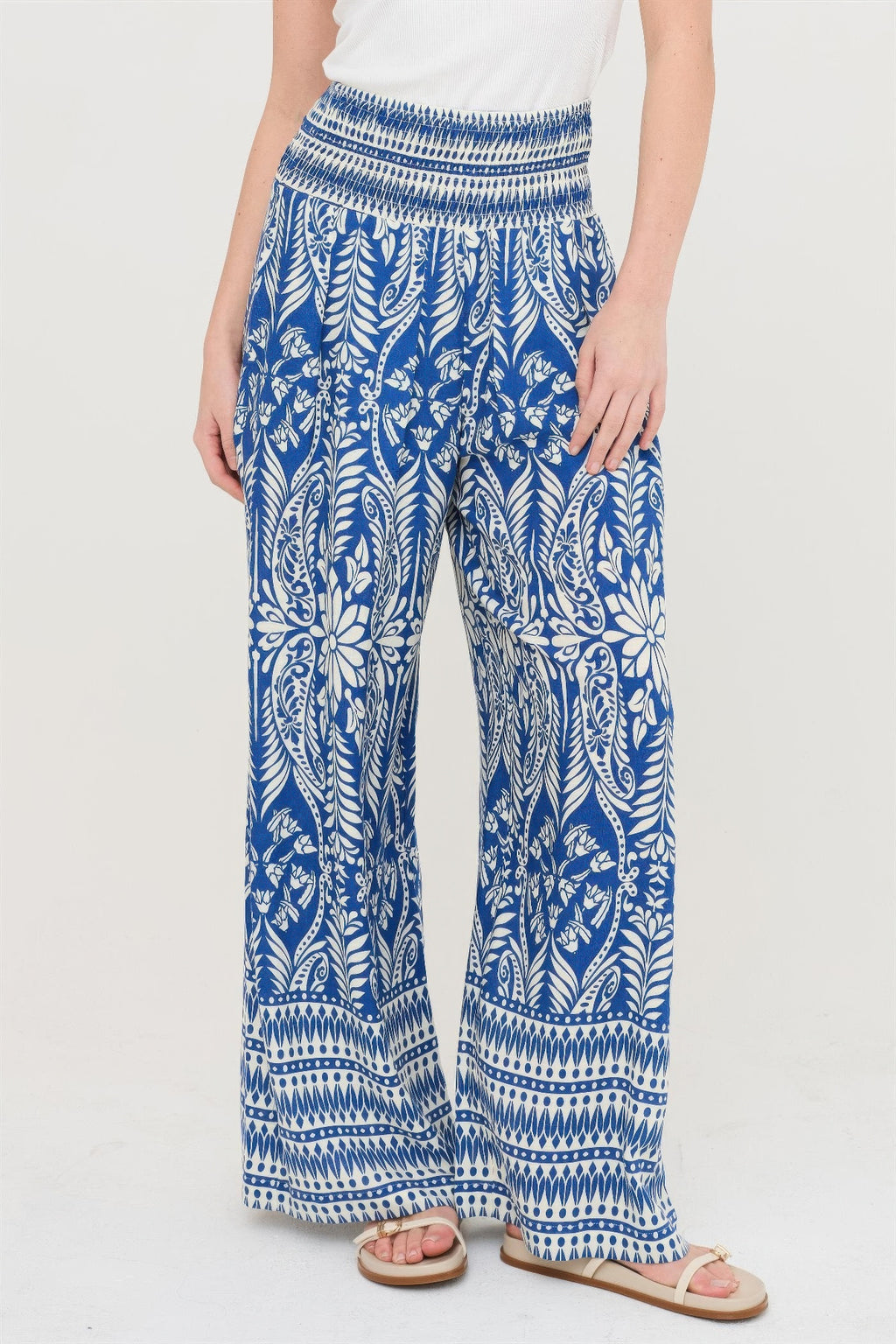 Smocked waist floral pants in blue with white leafy botanical border print