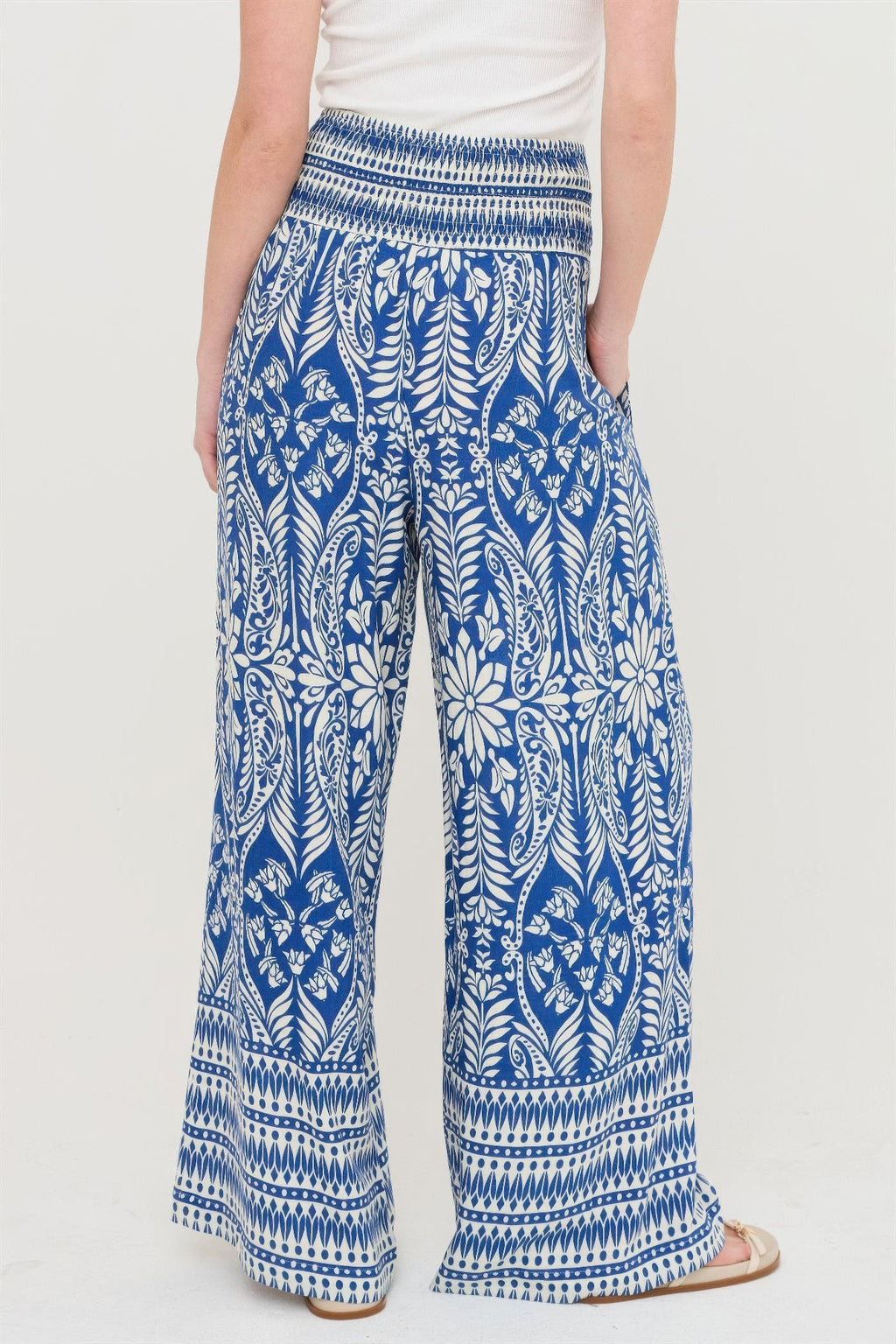 Blue smocked waist floral wide-leg pants with allover botanical print and patterned hem
