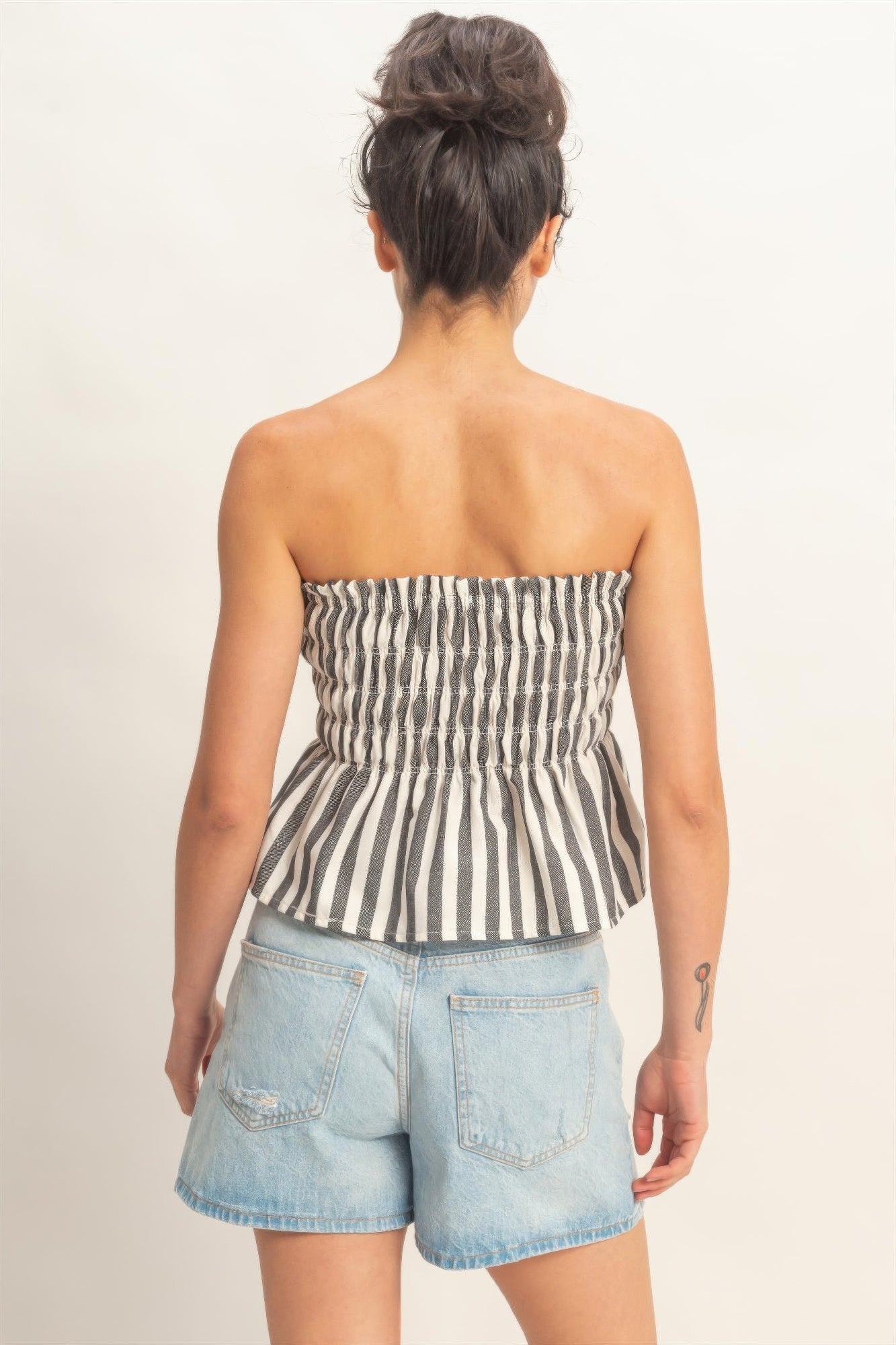 Vista trasera del top bandeau sin tirantes a rayas con fruncido elástico