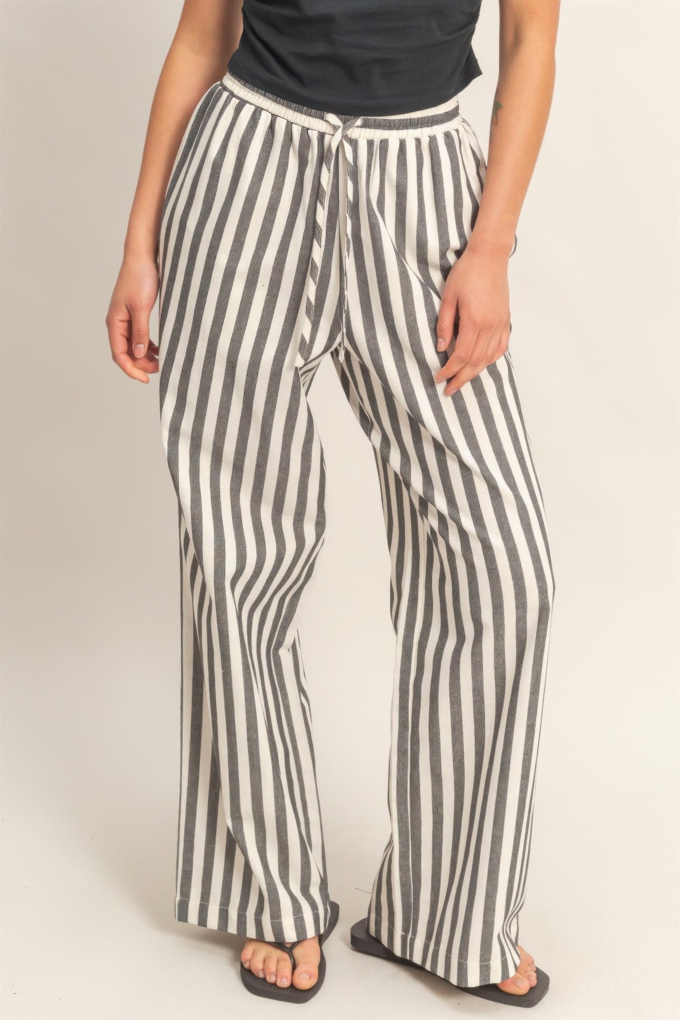 Black-and-white vertical striped elastic pants with drawstring waist and side pockets