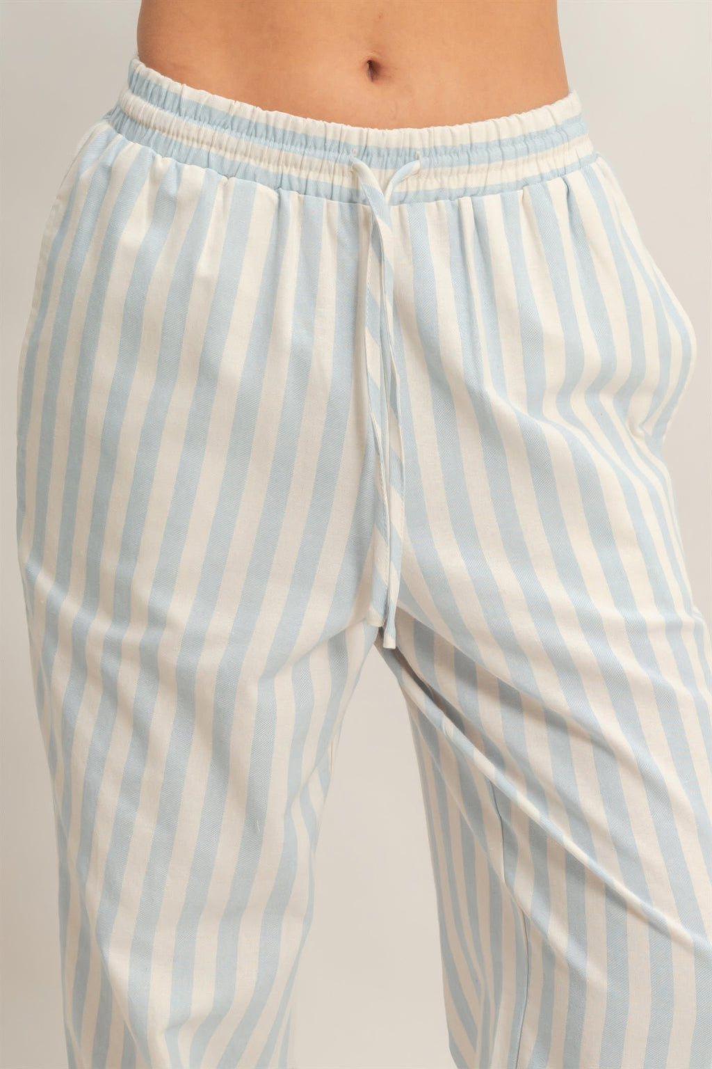 Elastic waistband pants with vertical blue-and-white stripes and drawstring