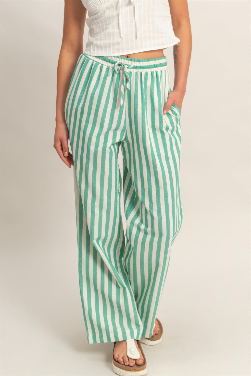 Green-and-white vertical striped pants with elastic waist, drawstring, and side pockets