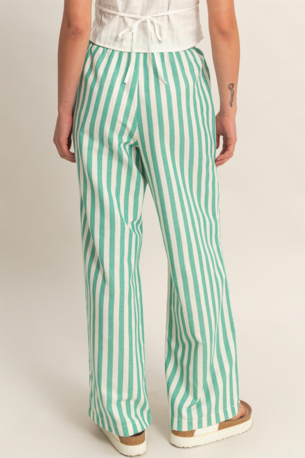 Green-and-white vertical striped elastic pants with side pockets and drawstring waist