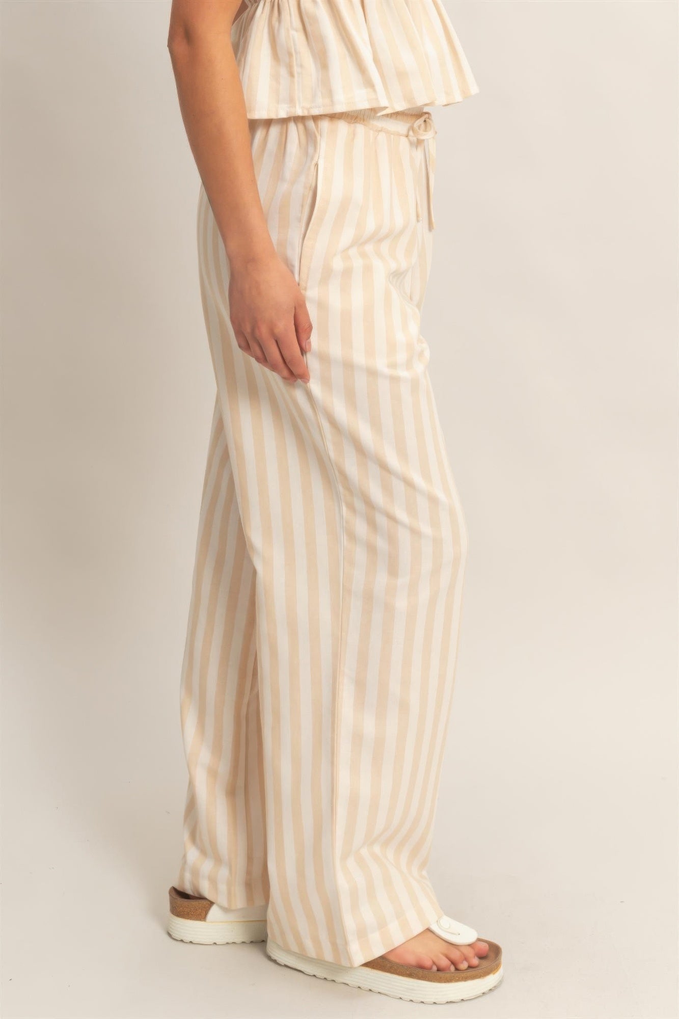 Cream vertical stripe elastic pants with relaxed wide legs and side pockets