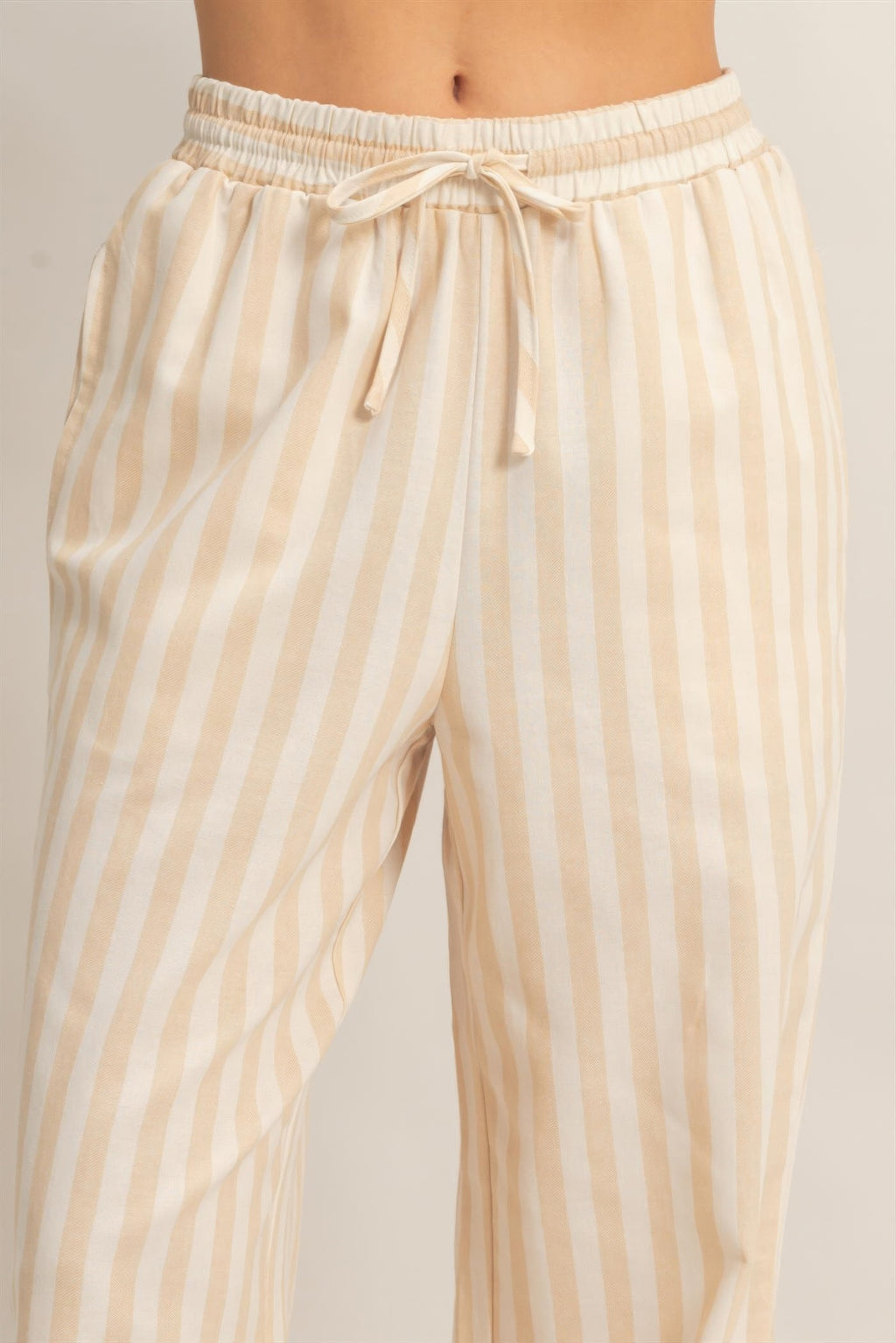Elastic waistband drawstring pants in cream with tan vertical stripes