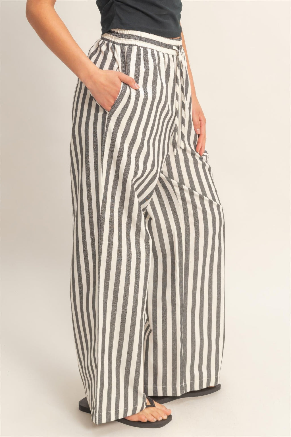 Black-and-white striped elastic waist pants with side pockets, relaxed wide legs