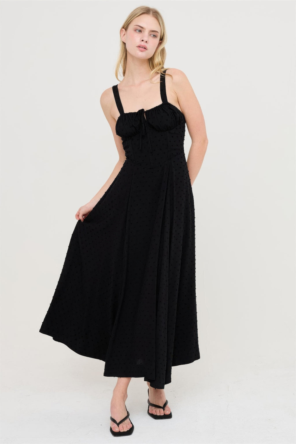Black tie-back dress with fitted bodice and full midi skirt with allover texture.