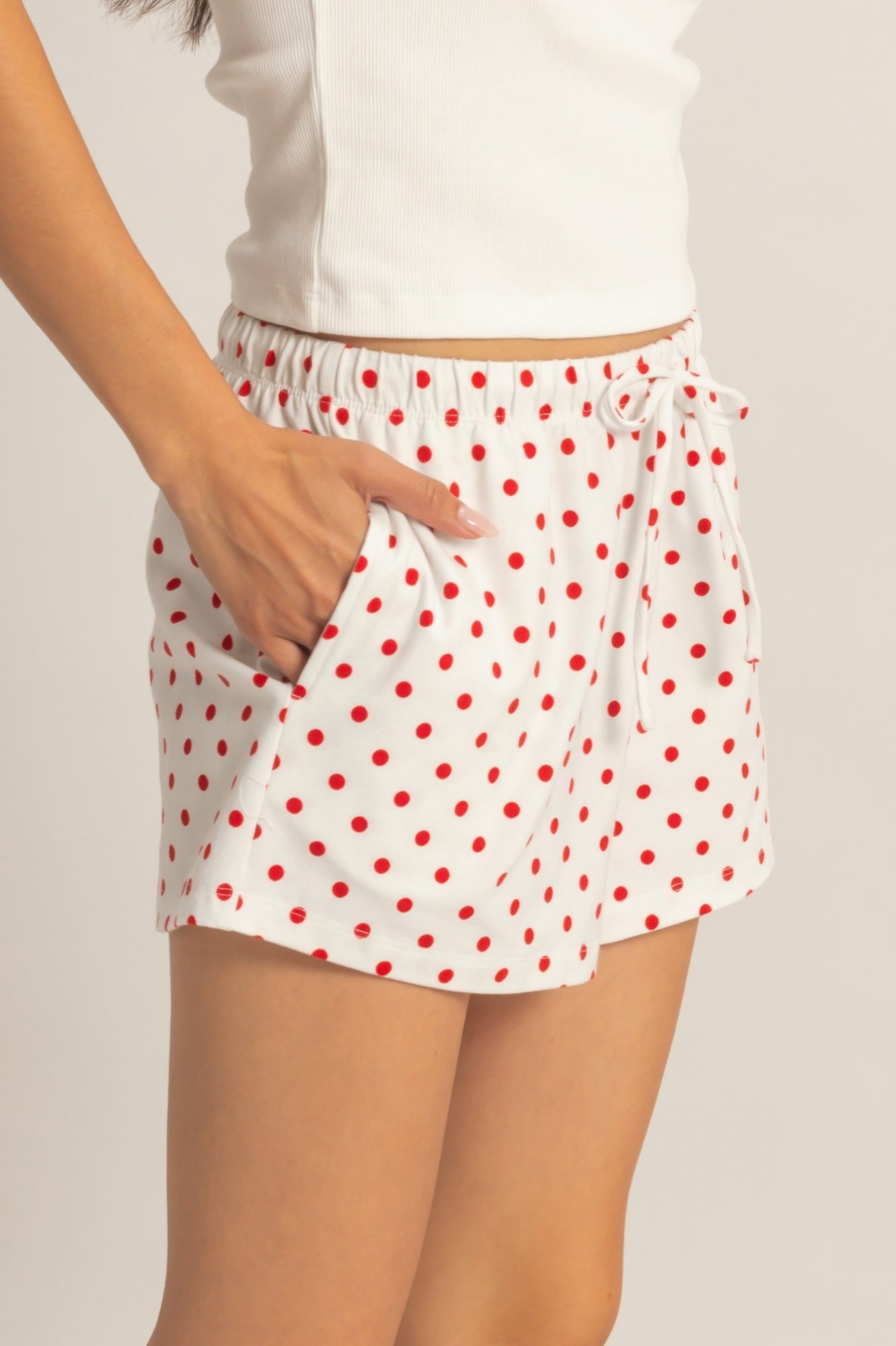 Polka dot drawstring shorts with red dot print and front tie at elastic waist.