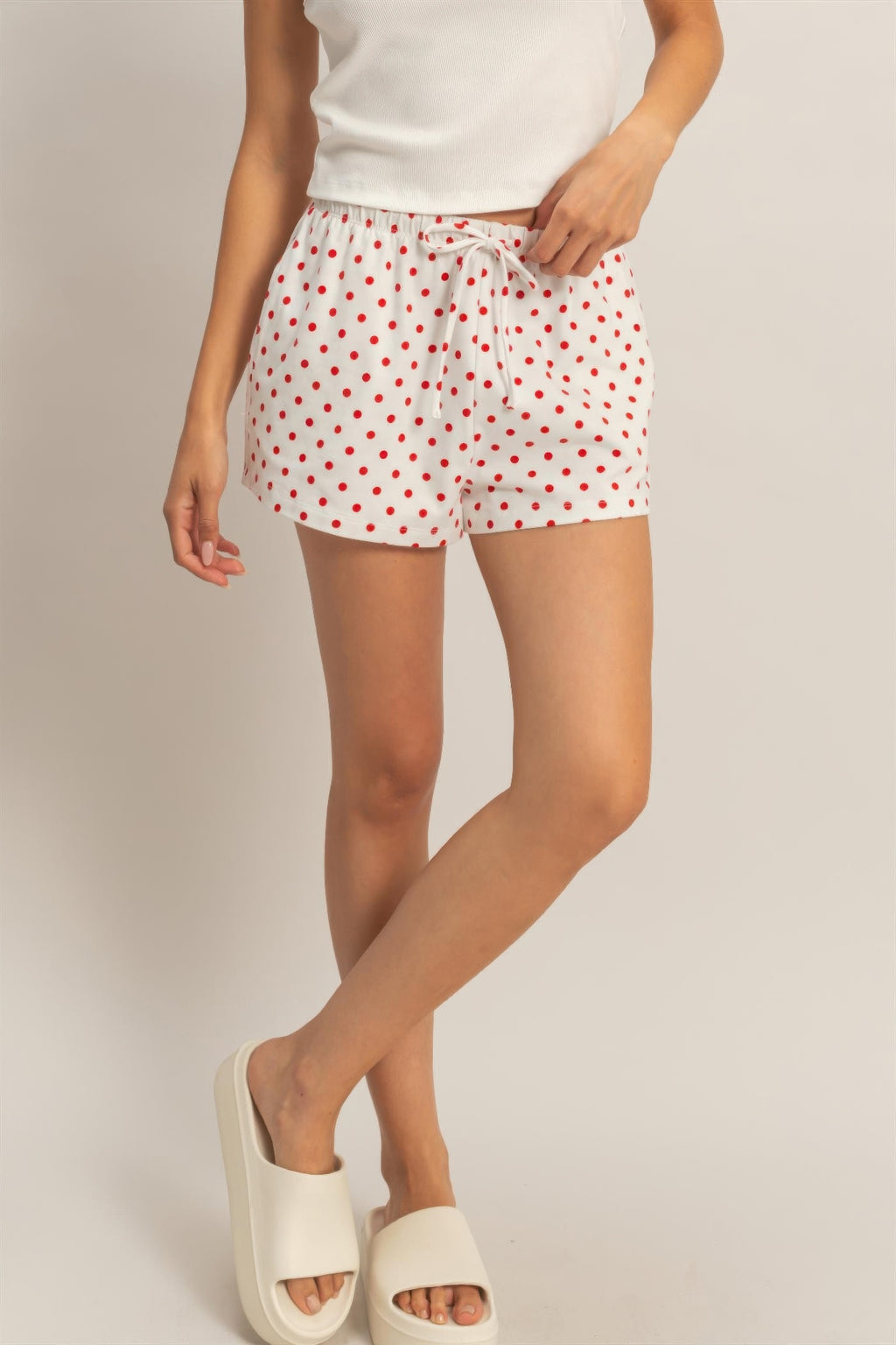White polka dot drawstring shorts with red dots, elastic waist and drawstring bow.