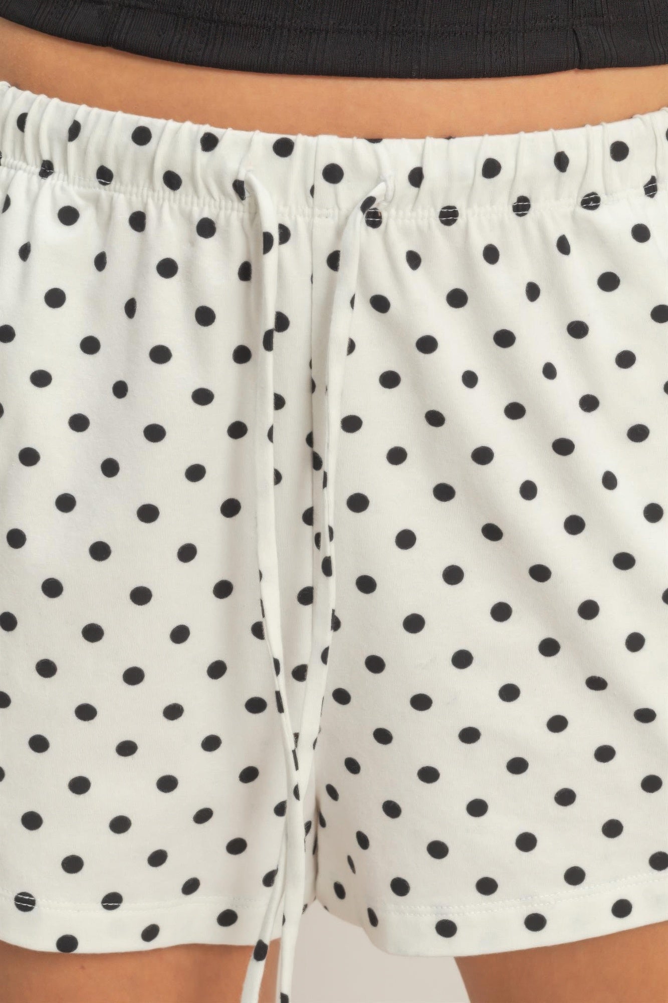 White polka dot drawstring shorts with black dots, front drawstring tie