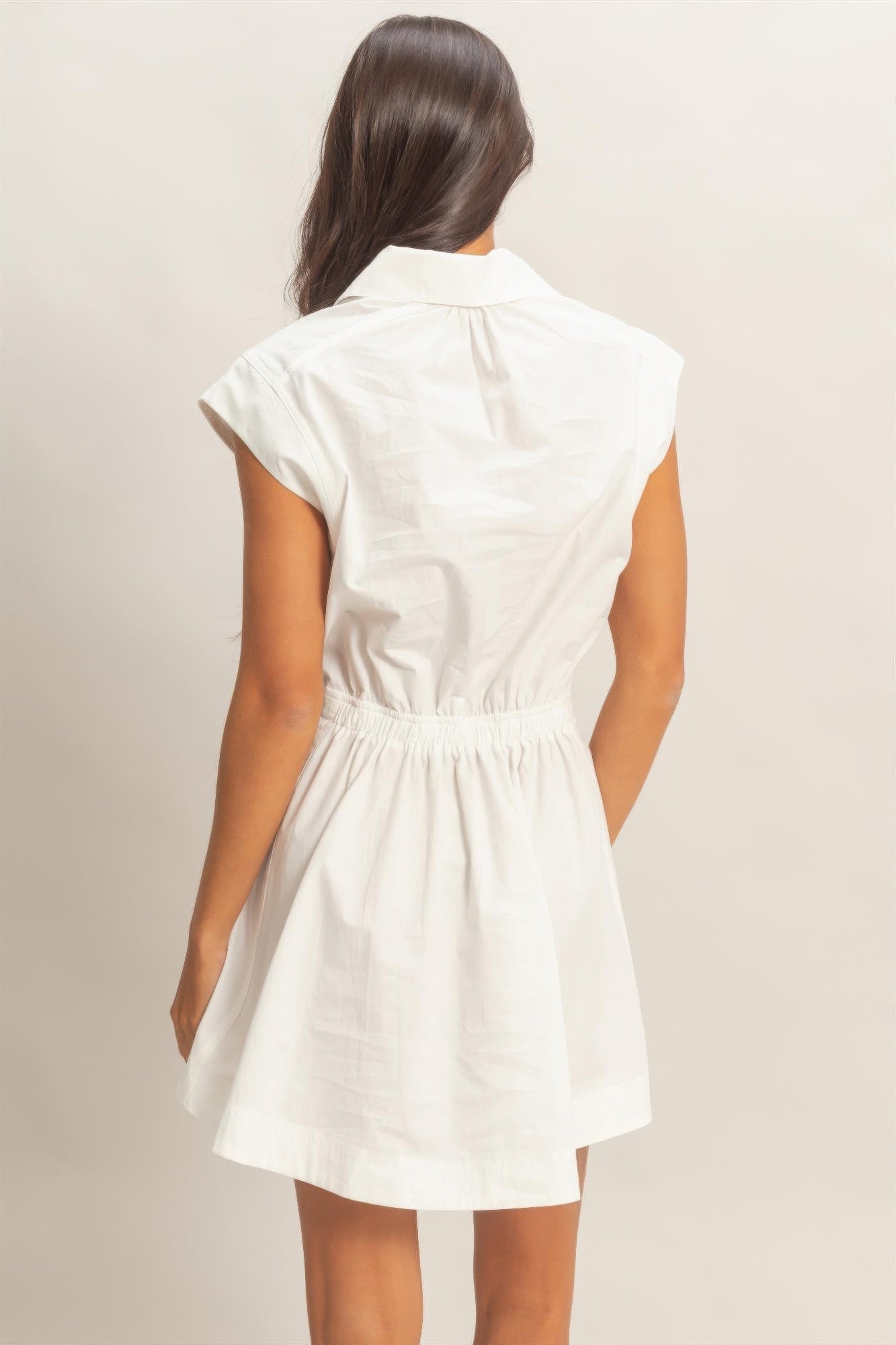 Back view of white sleeveless mini dress with point collar and gathered waist