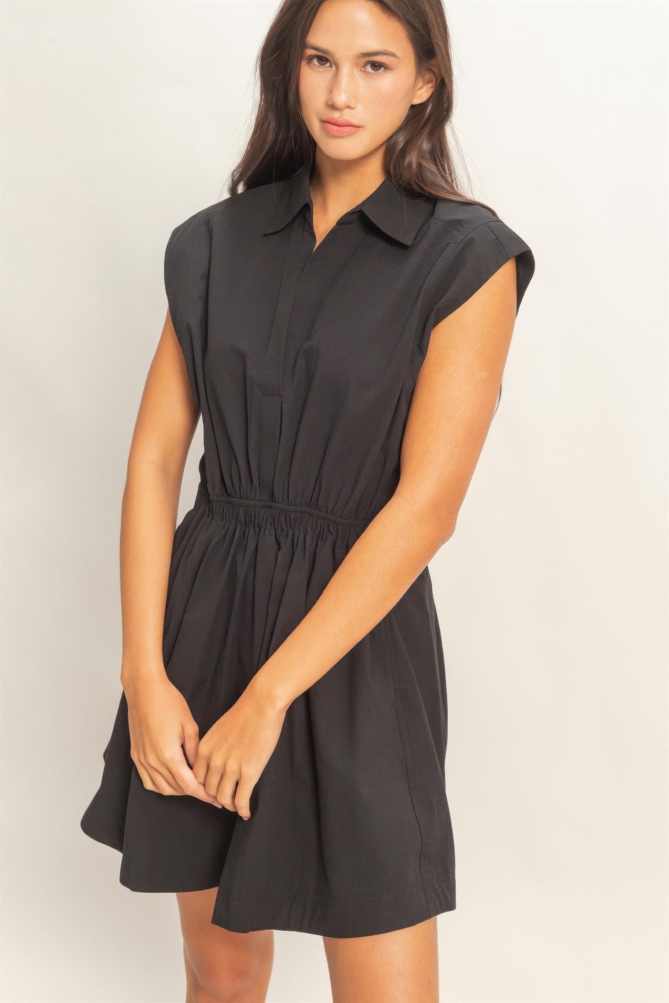 Black sleeveless mini dress with collared button placket and shirred waist