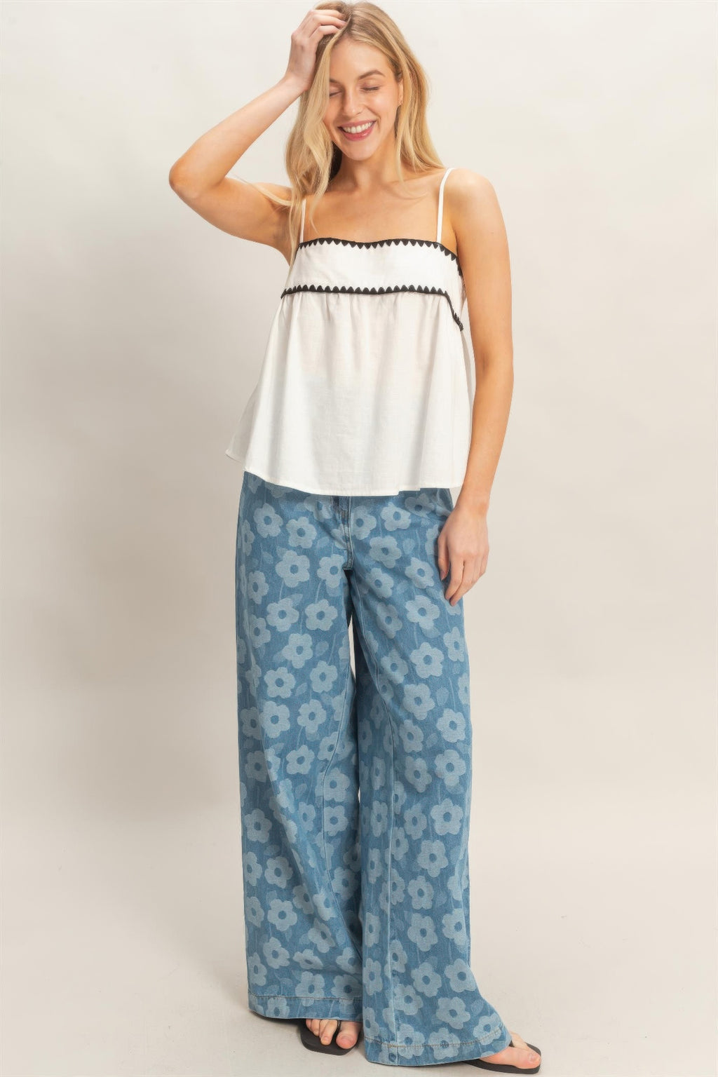 White babydoll top with black scalloped trim paired with blue floral wide-leg pants