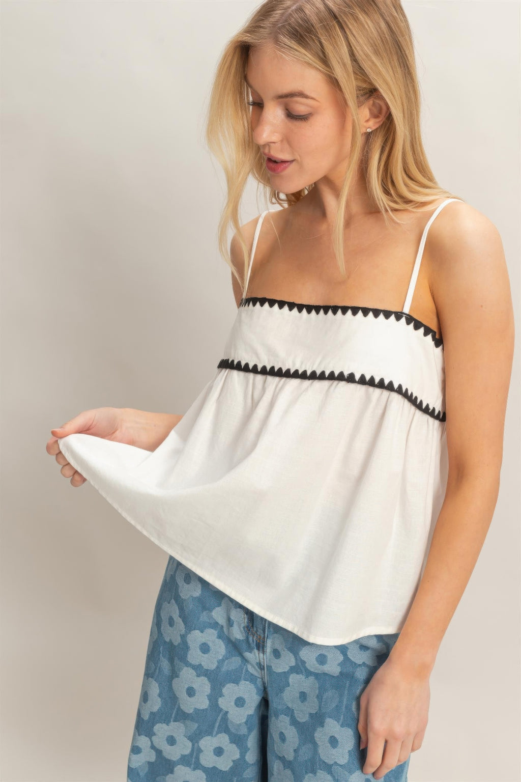 White babydoll top detail: black trim band and tiered ruffle skirt