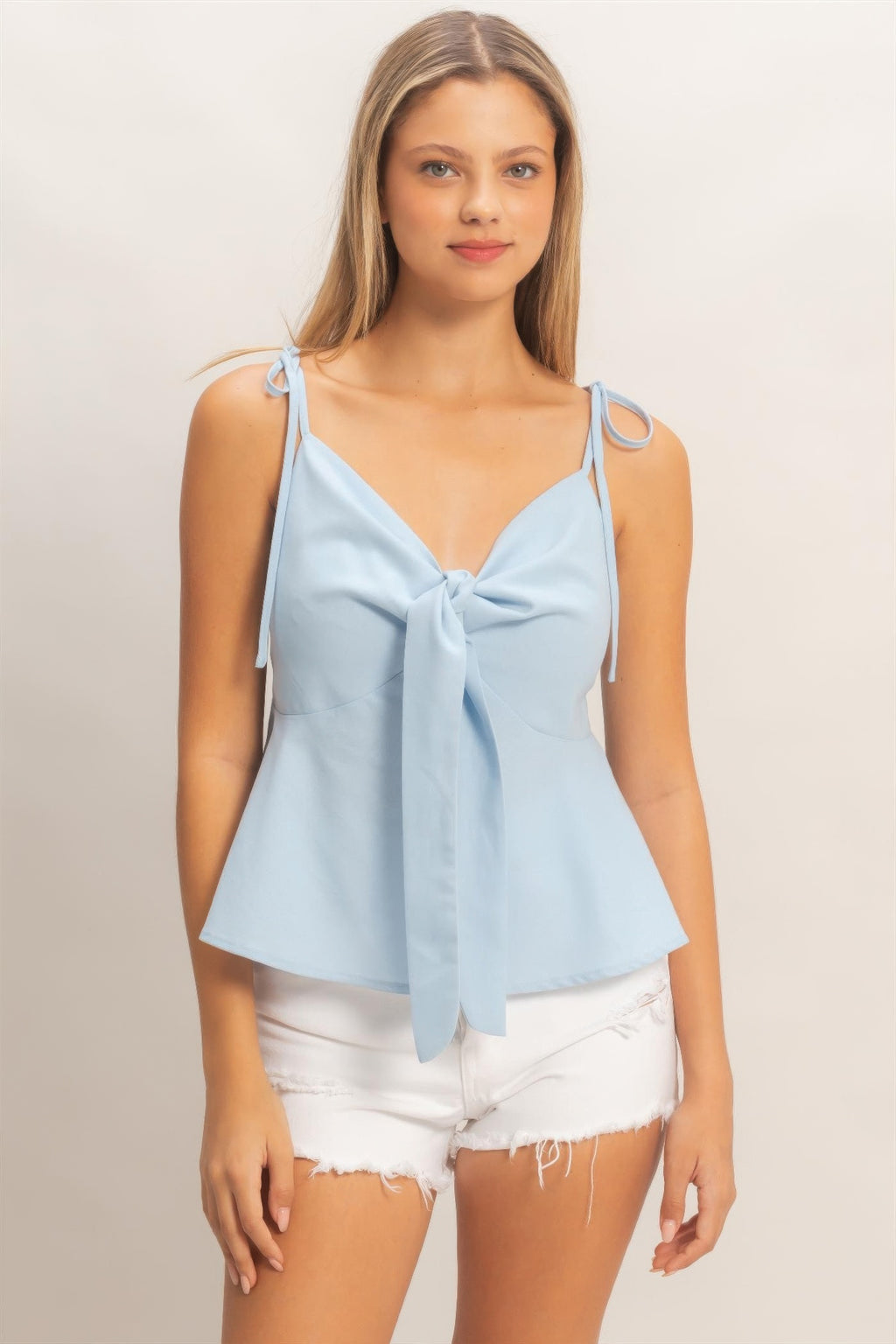 Light blue tie-front spaghetti strap peplum top with bow at center