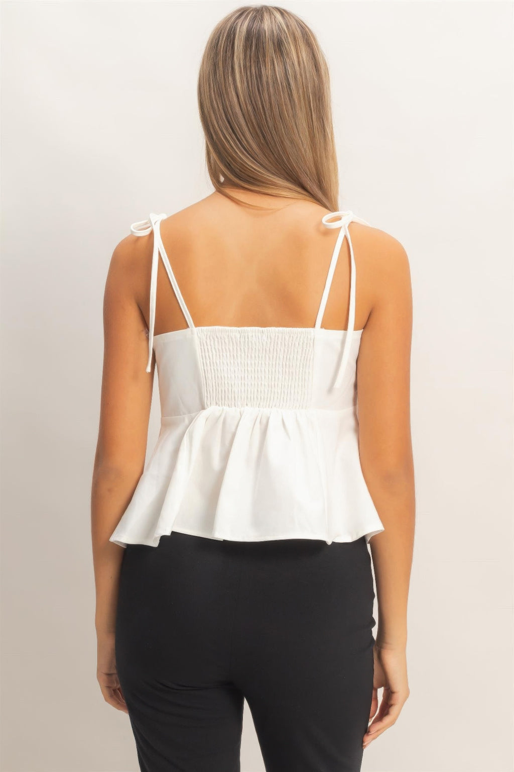 Back view: ivory tie-front spaghetti strap peplum top with smocked panel