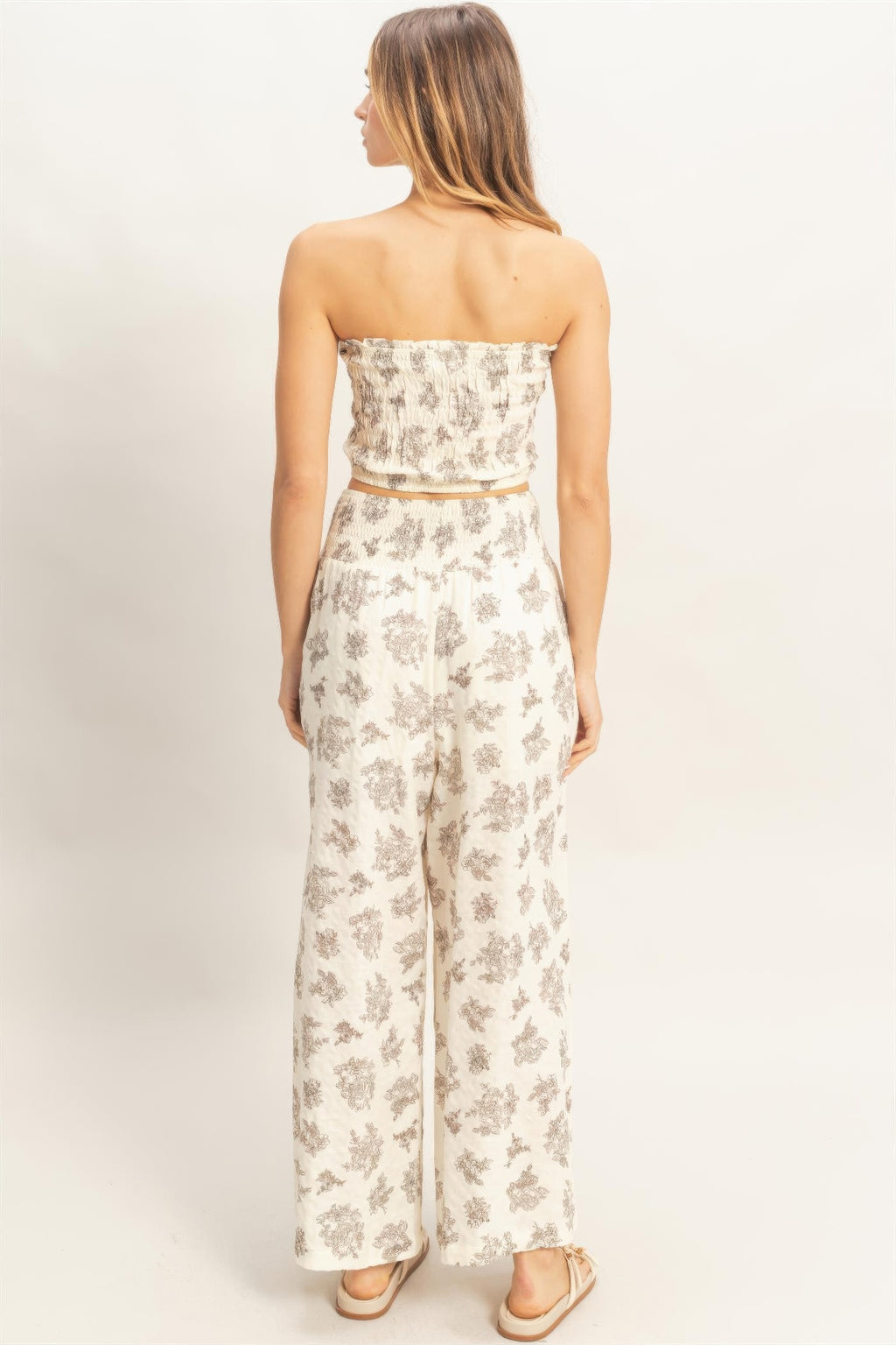 Back view of smocked tube top & wide-leg pants set; light base with gray floral print.