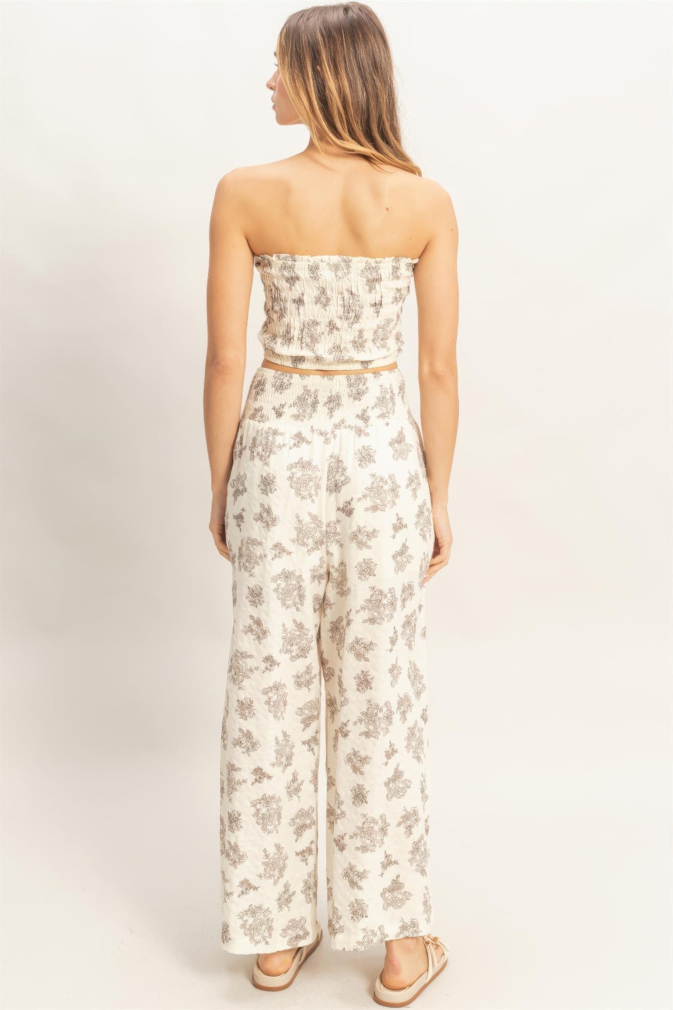 Back view of smocked tube top & wide-leg pants set; light base with gray floral print.