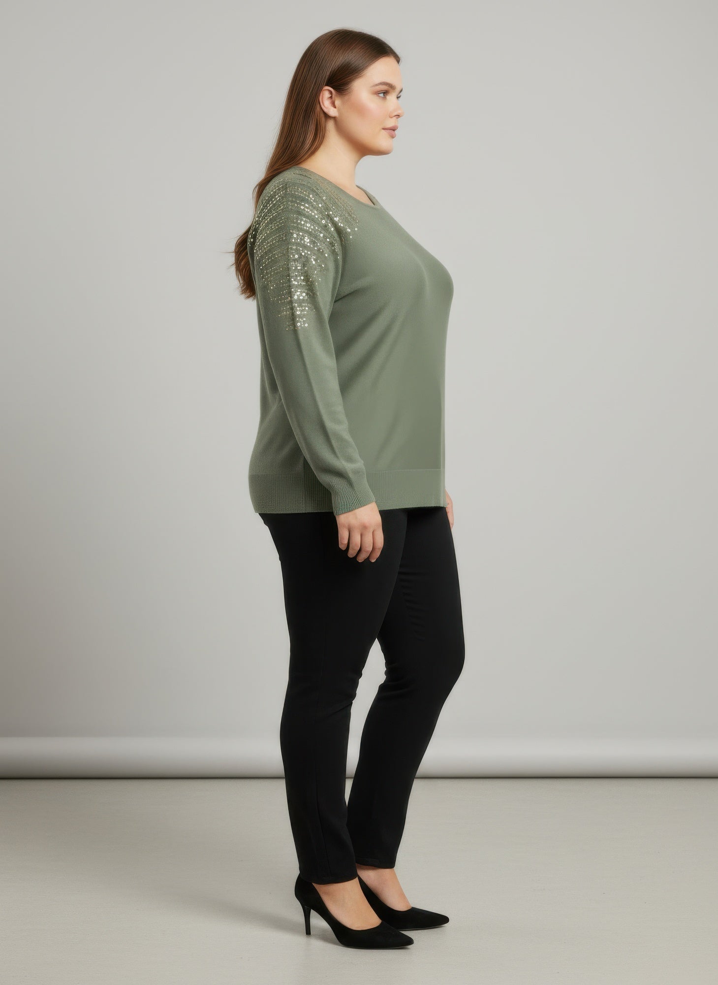 Green tunic top side view with sequined shoulder sleeves and knit cuffs