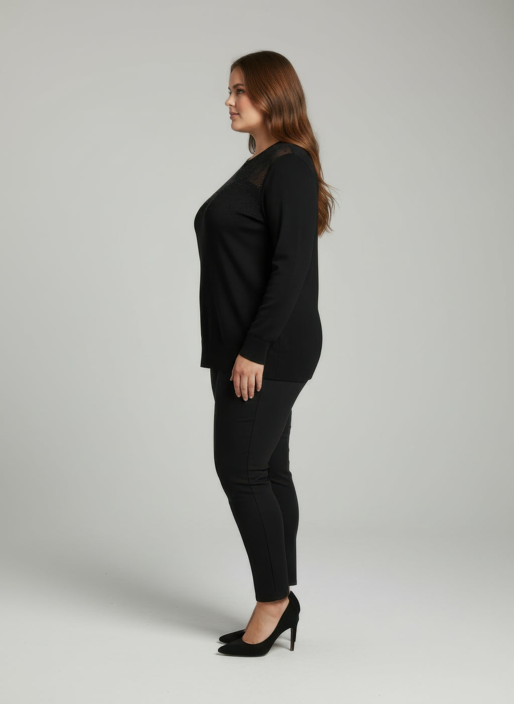 Black knit tunic top with mesh yoke detail, long sleeves, side view