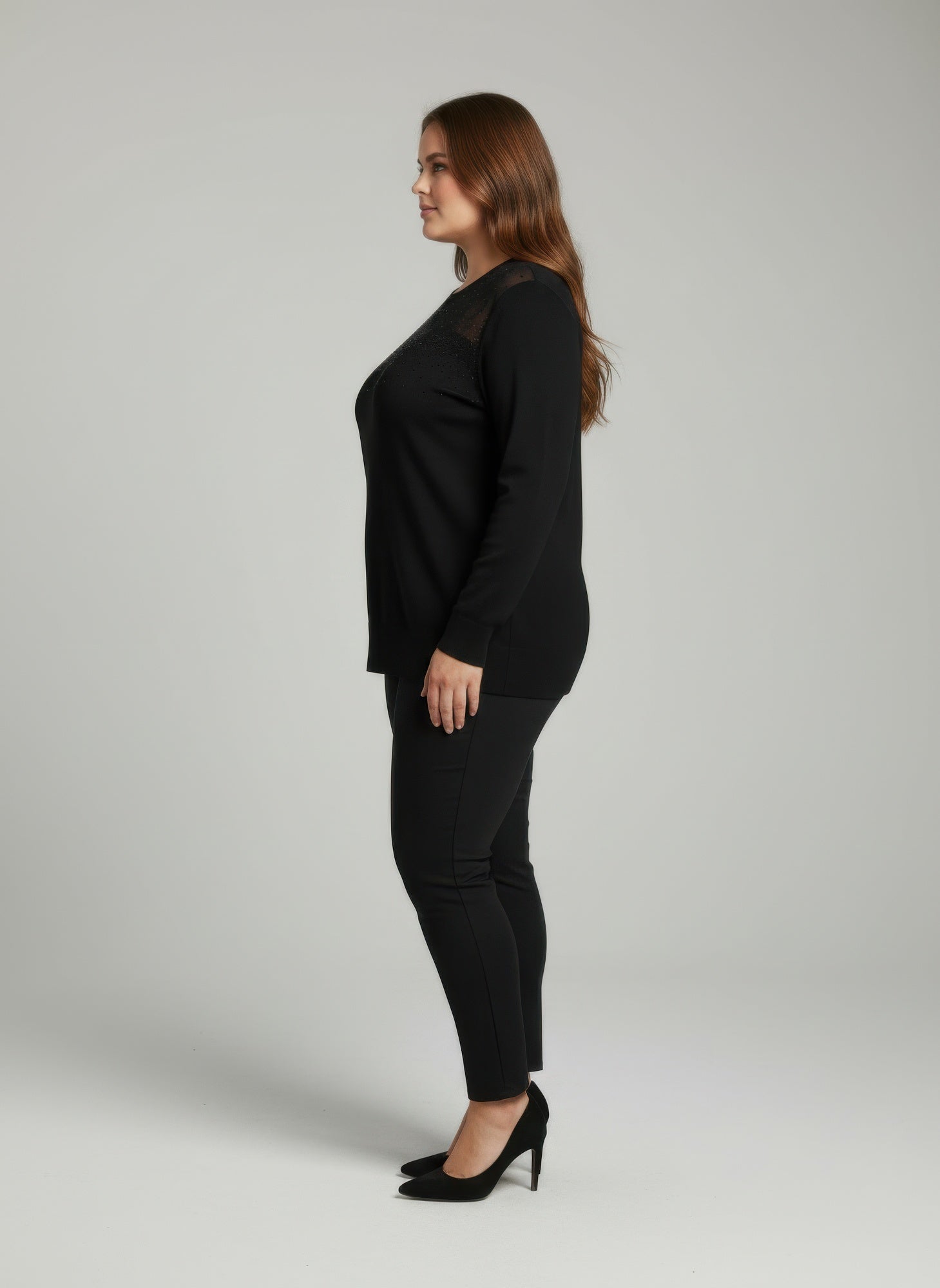 Black knit tunic top with mesh yoke detail, long sleeves, side view