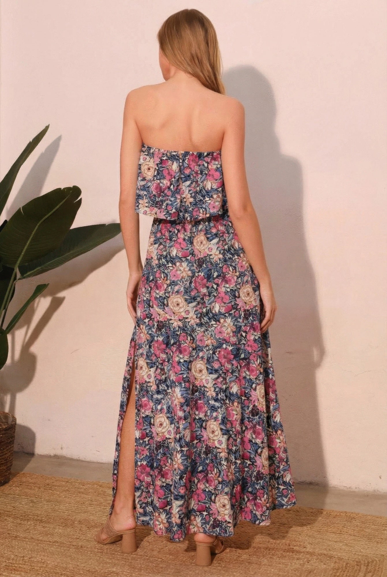 Back view of strapless floral maxi dress with tiered skirt and side slit