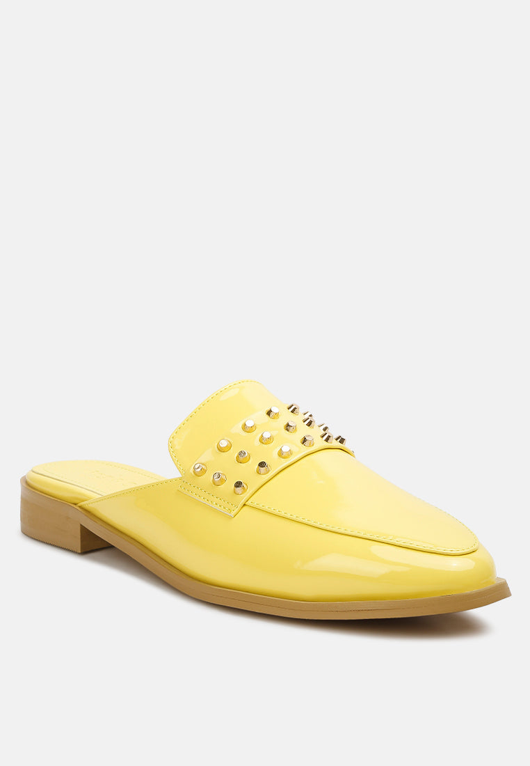 Yashta patent studded flat mules in yellow, angled profile with square heel