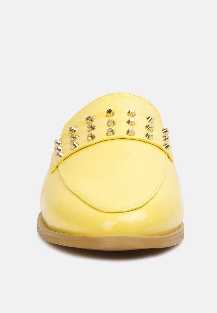 Yellow patent flat mule back view with studded heel panel and rounded toe