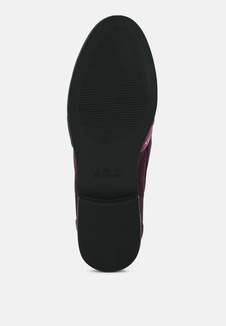 Schwarze Profilsohle eines burgunder Velours-Loafers