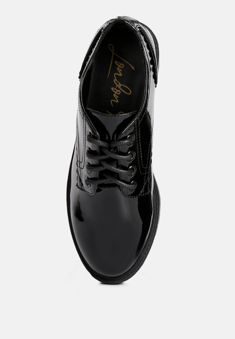 Black patent lace-up derby shoes, close-up of front and laces