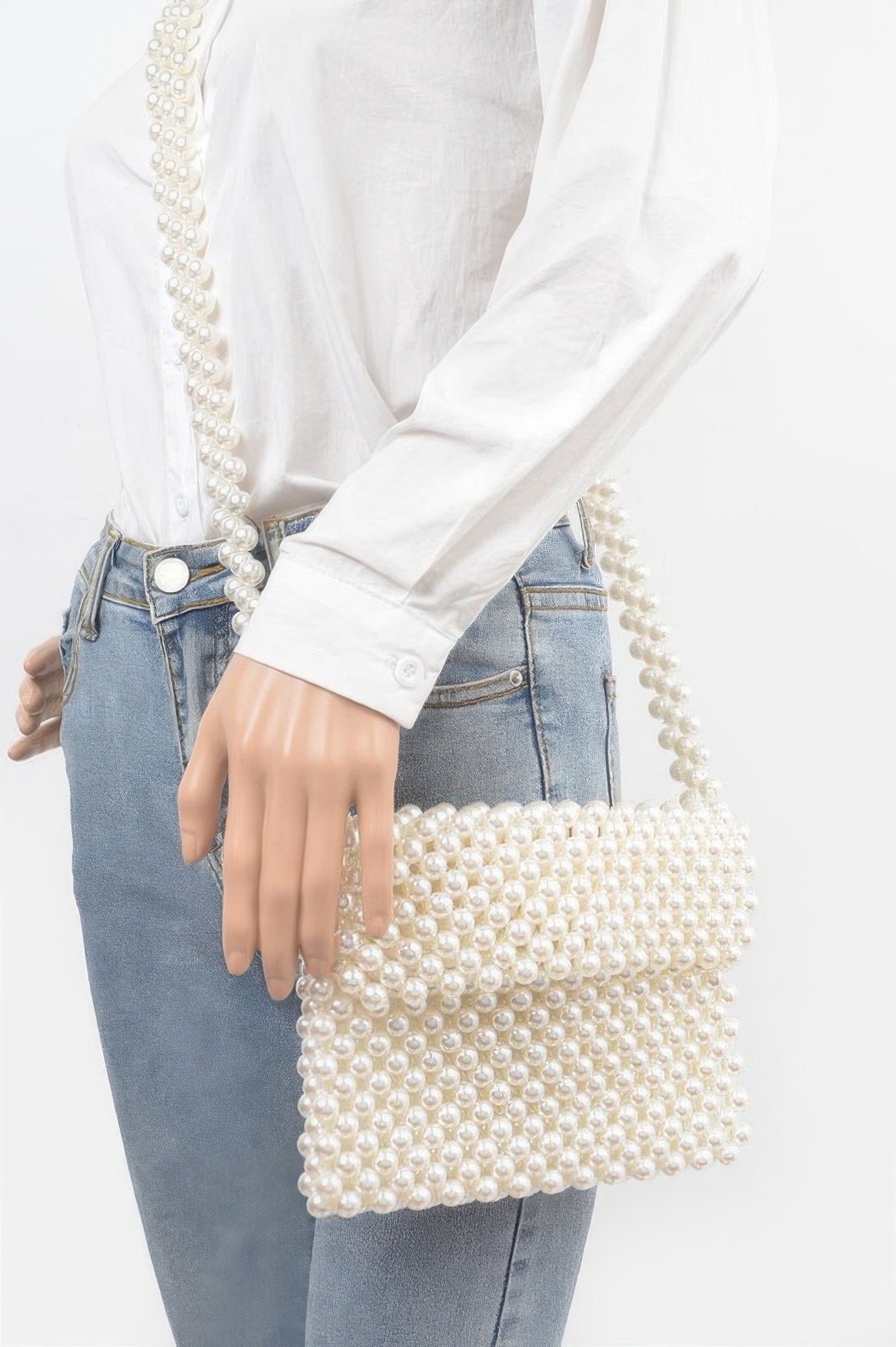 Cream faux pearl beaded flap crossbody bag worn crossbody over denim