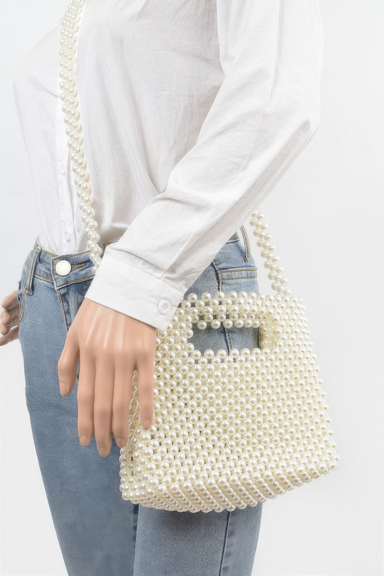 Creme Faux-Perlen Crossbody-Tasche am Arm getragen, Schulterriemen aus Perlen