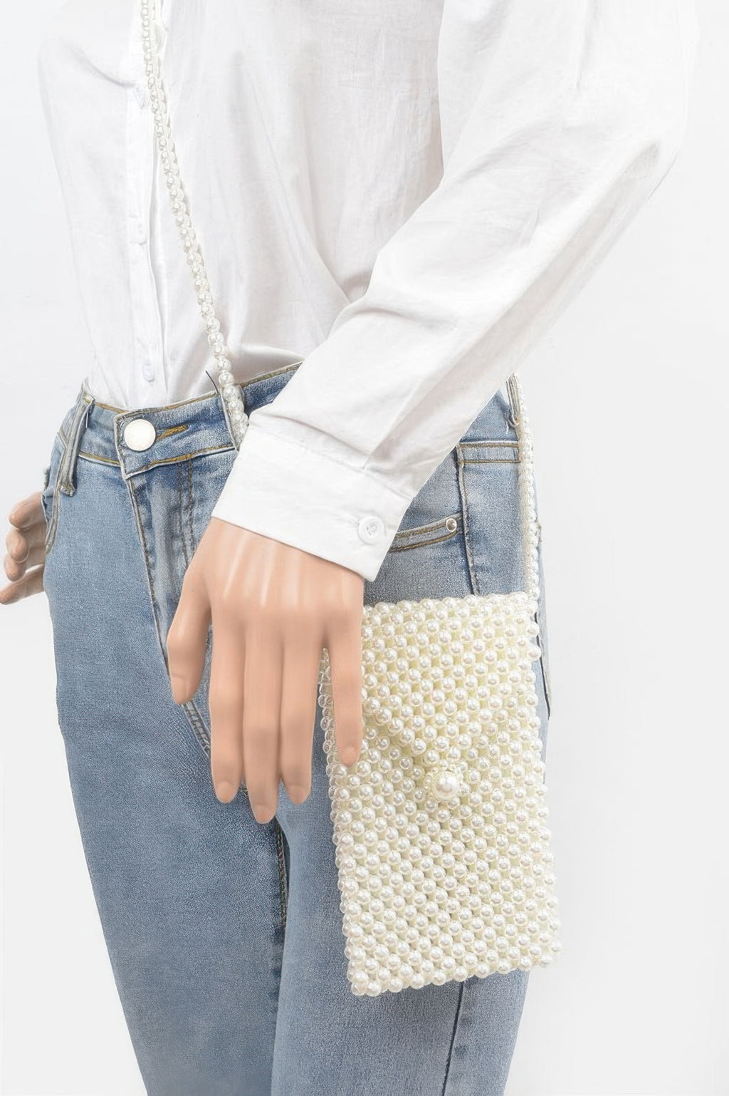 Cream faux pearl beaded crossbody bag worn over shoulder with long strap