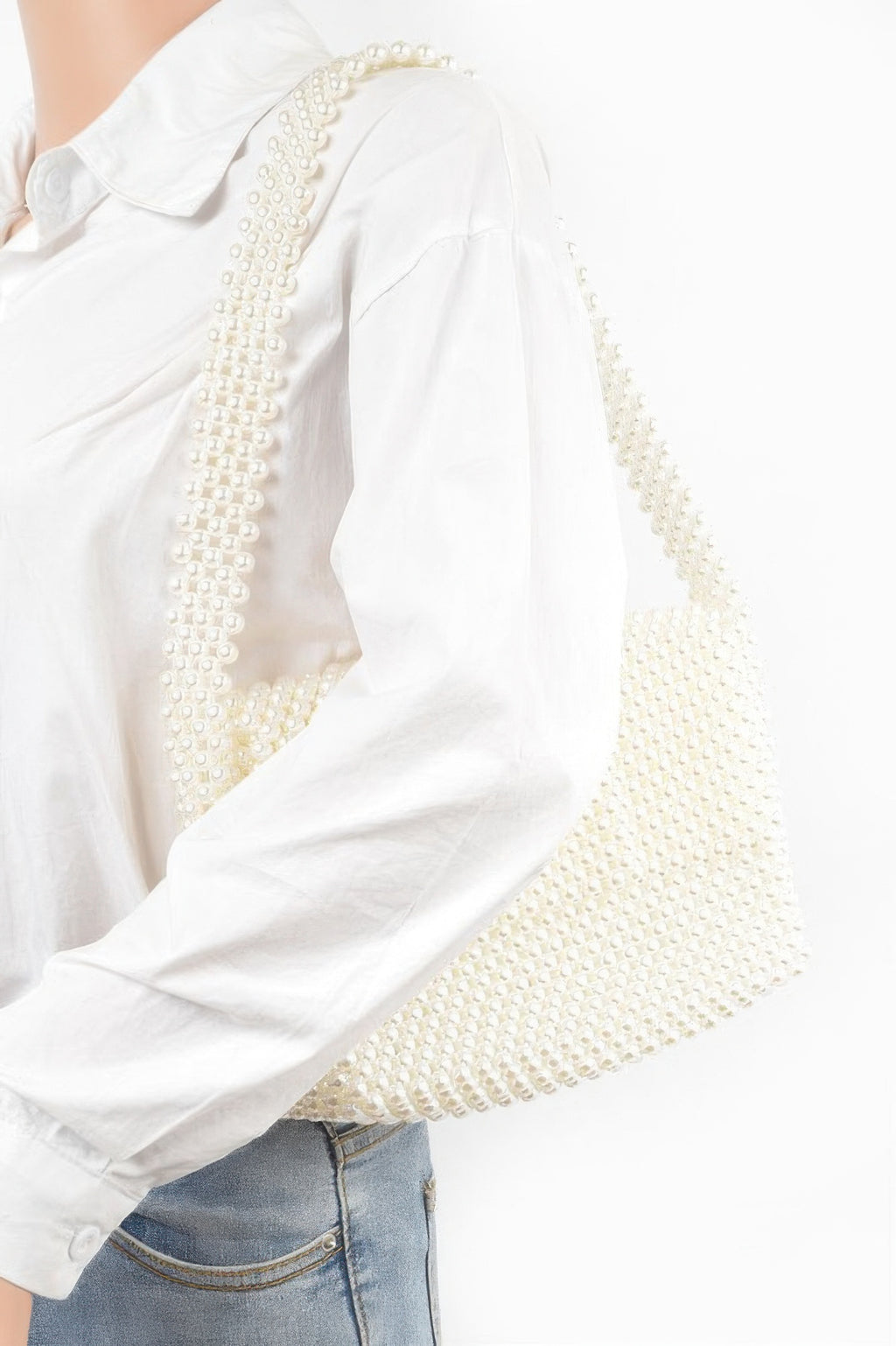 Cream faux pearl bead flap shoulder bag, worn over white shirt with handle across arm