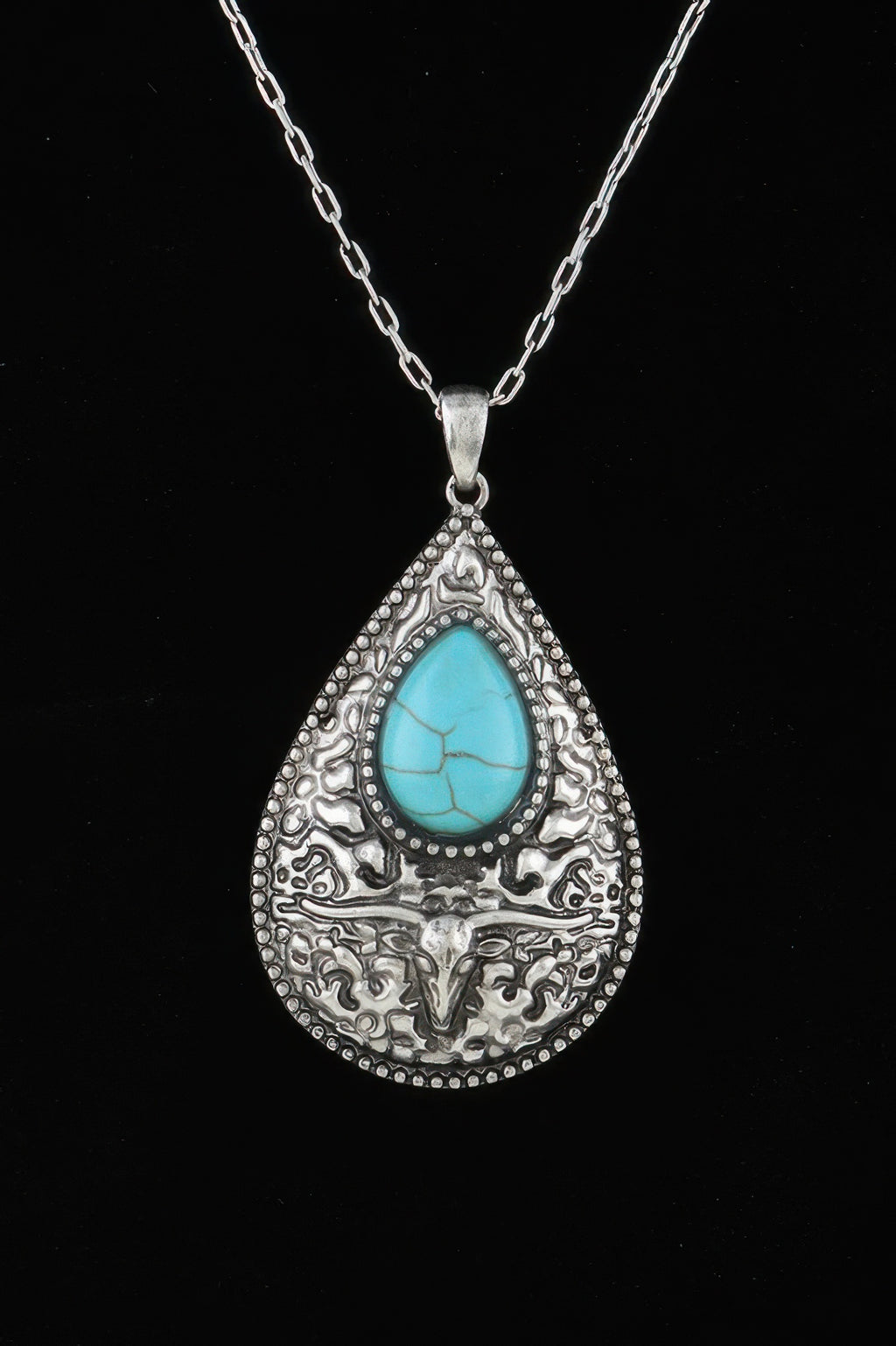 Silver-tone bull teardrop pendant necklace with turquoise cabochon and ornate engraving
