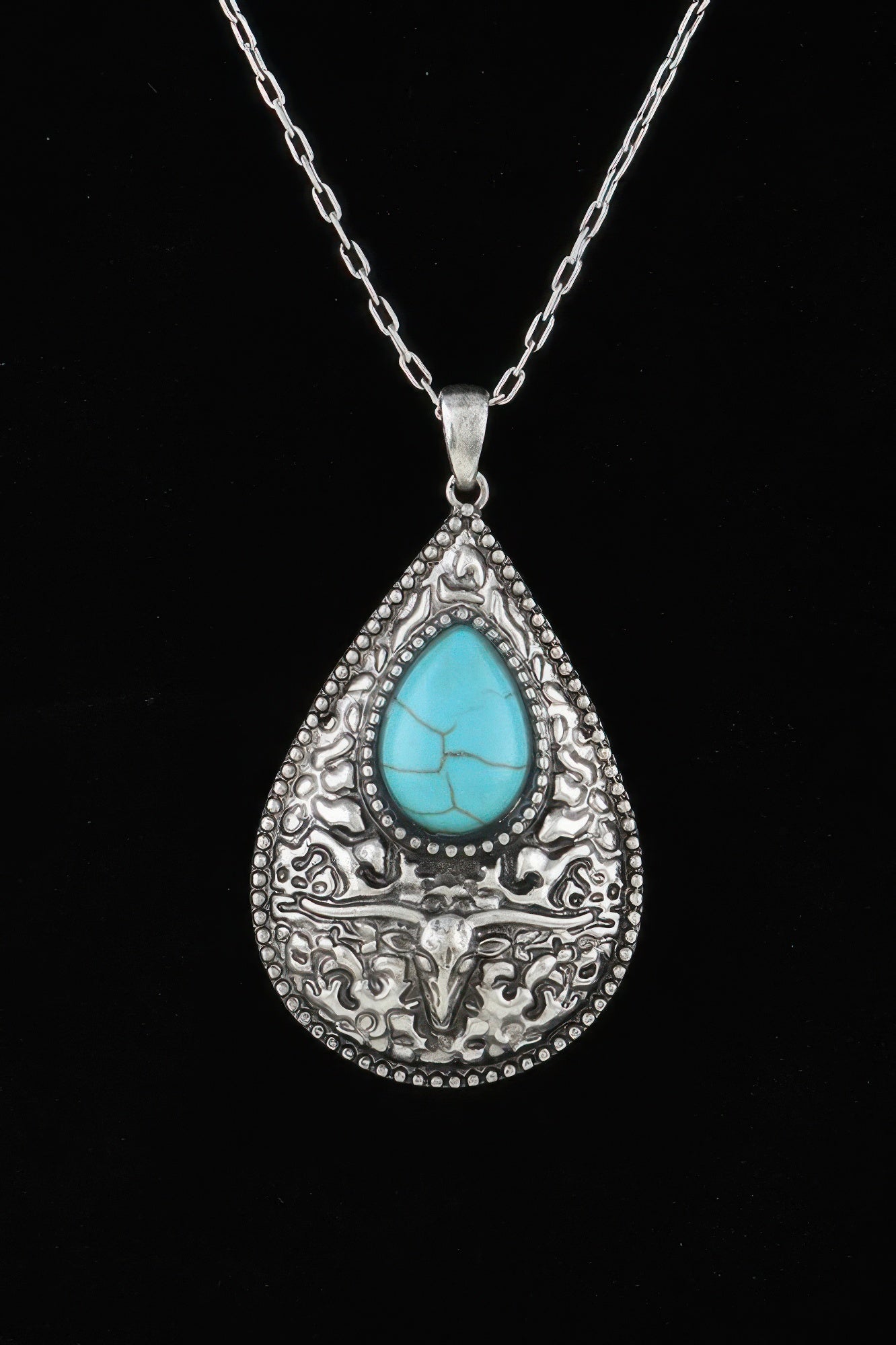 Silver-tone bull teardrop pendant necklace with turquoise cabochon and ornate engraving