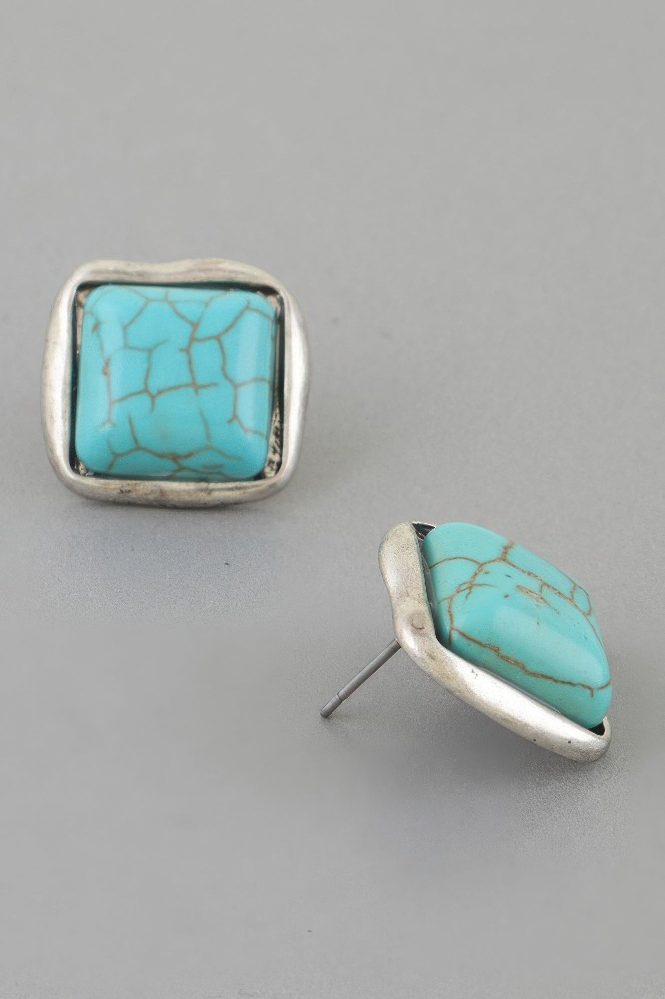 Turquoise cracked-stone cubic stud earrings, silver-tone setting and post backing visible