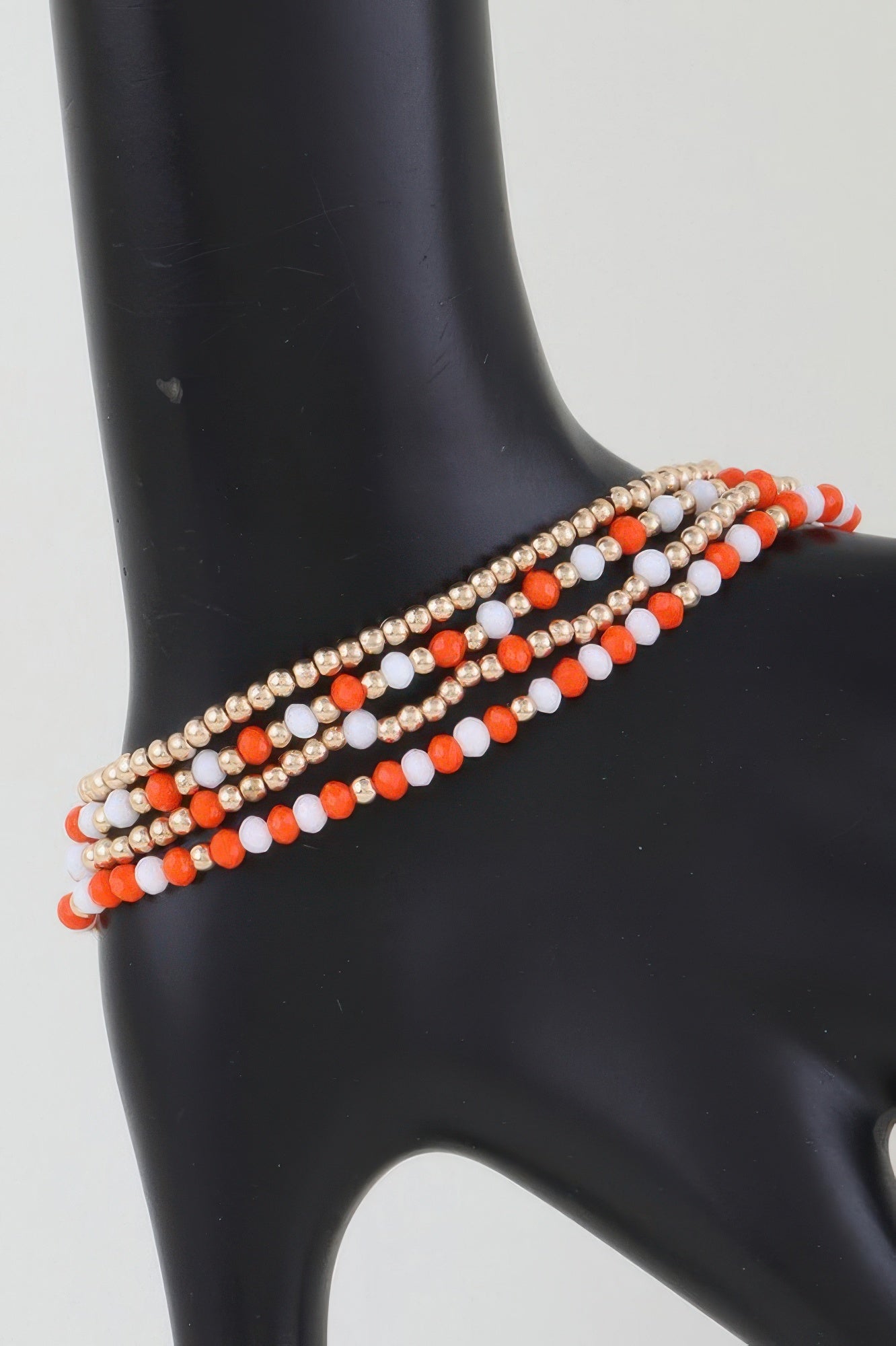 Alternating stone beaded bracelet with gold beads and orange-and-white beads