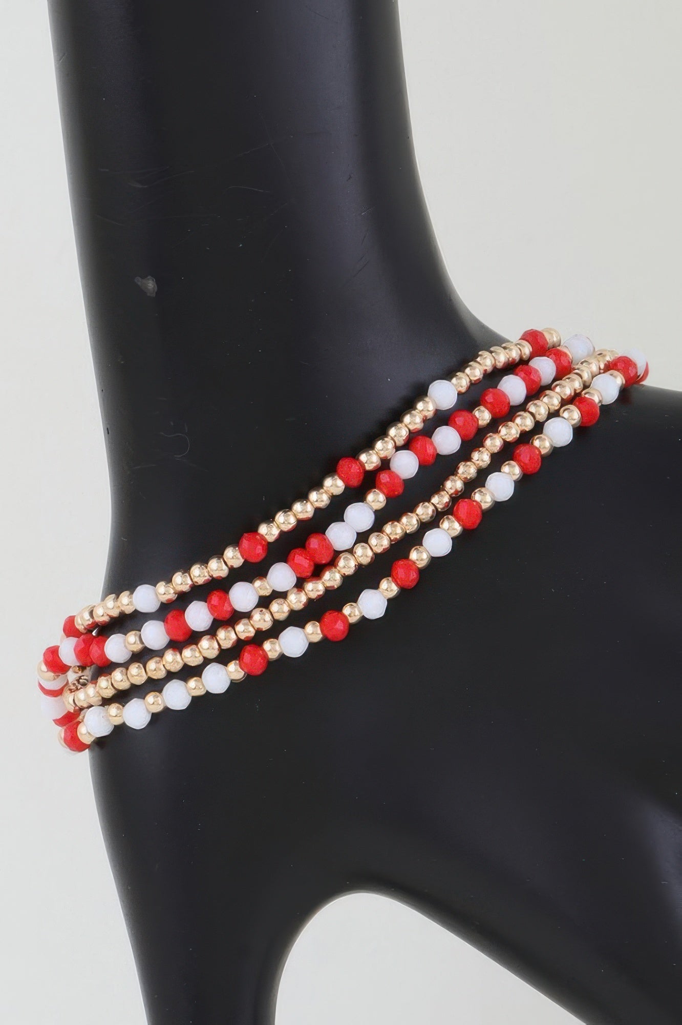 Alternating stone beaded bracelet with gold beads and red-and-white bead rows
