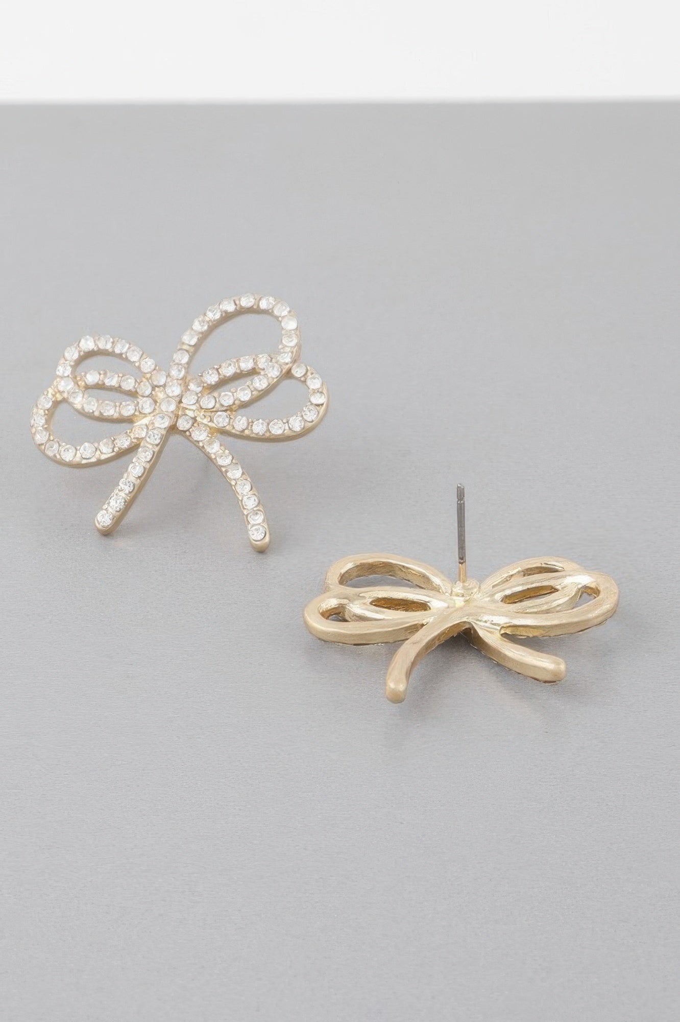 Double jeweled ribbon earrings with bow details, gold-tone setting and pearl-like stones