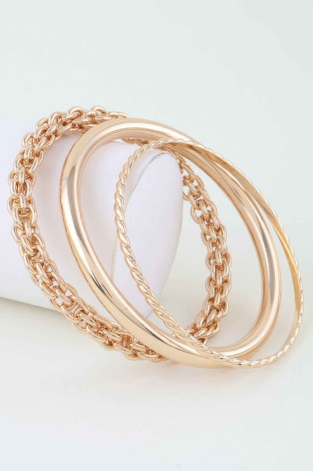 Gold multi-link chain wrap bracelet with stacked bangles and braided chain detail