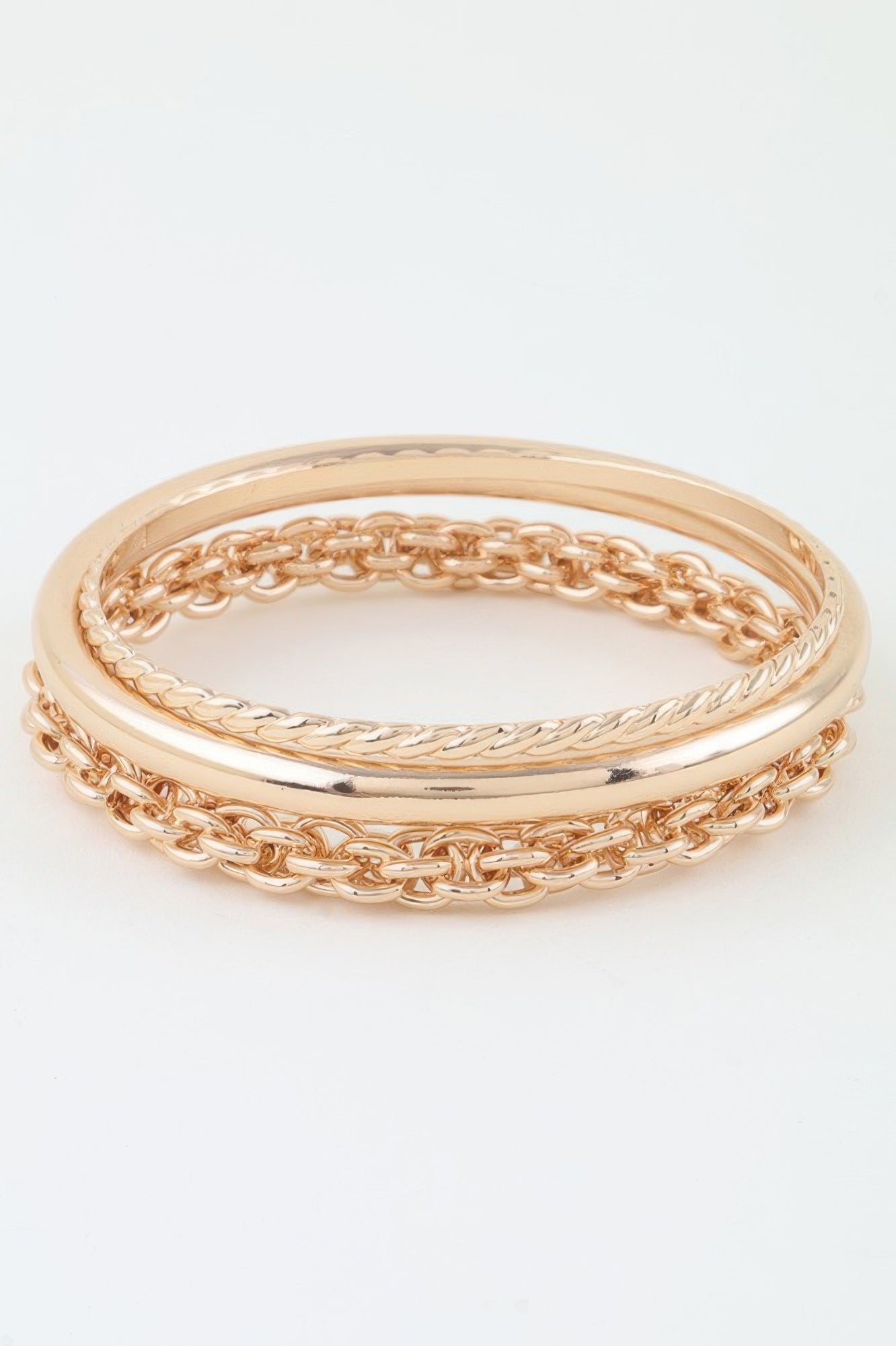 Gold chain wrap bracelet stacked with smooth bangles and curb-link segments