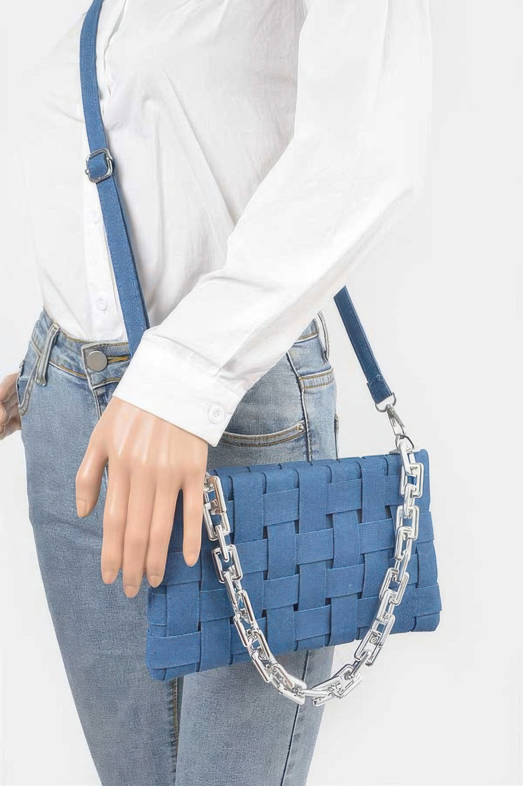 Blue denim braided shoulder bag with silver chain strap worn crossbody on model