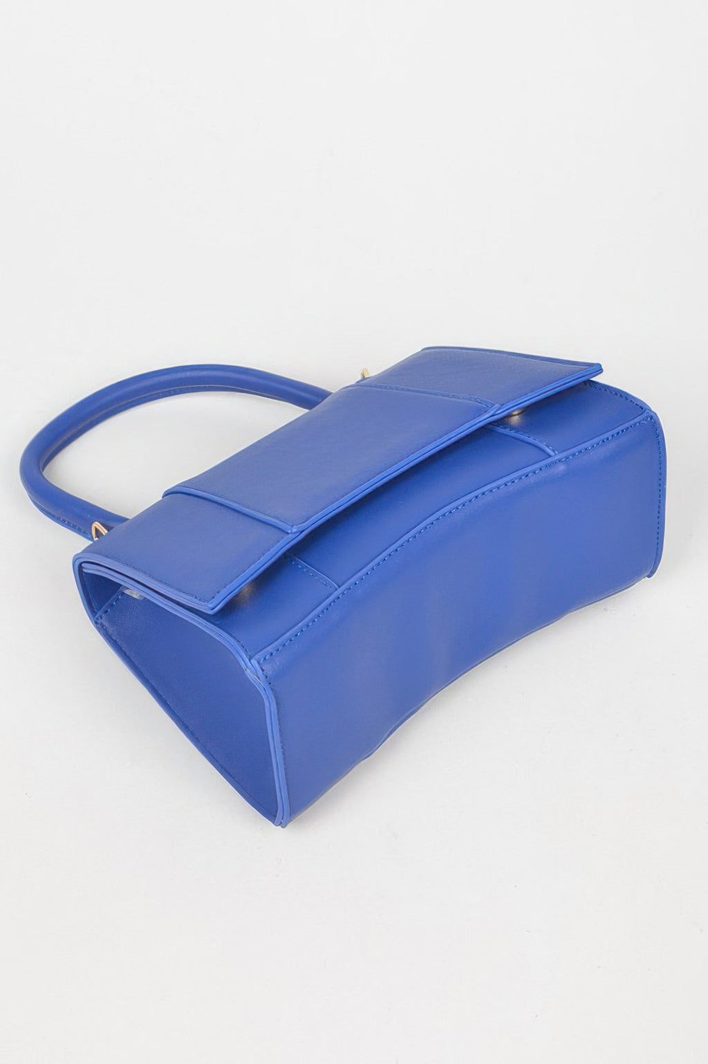 Cobalt blue faux leather top-handle bag side view with flap and shoulder strap